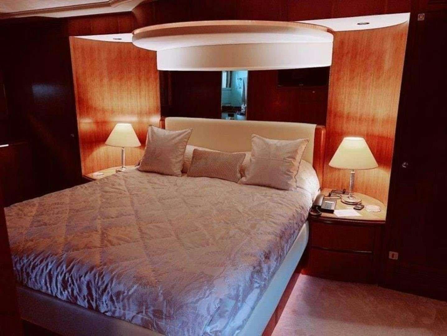a bed with lamps on either side aboard ILLYA F Yacht for Charter