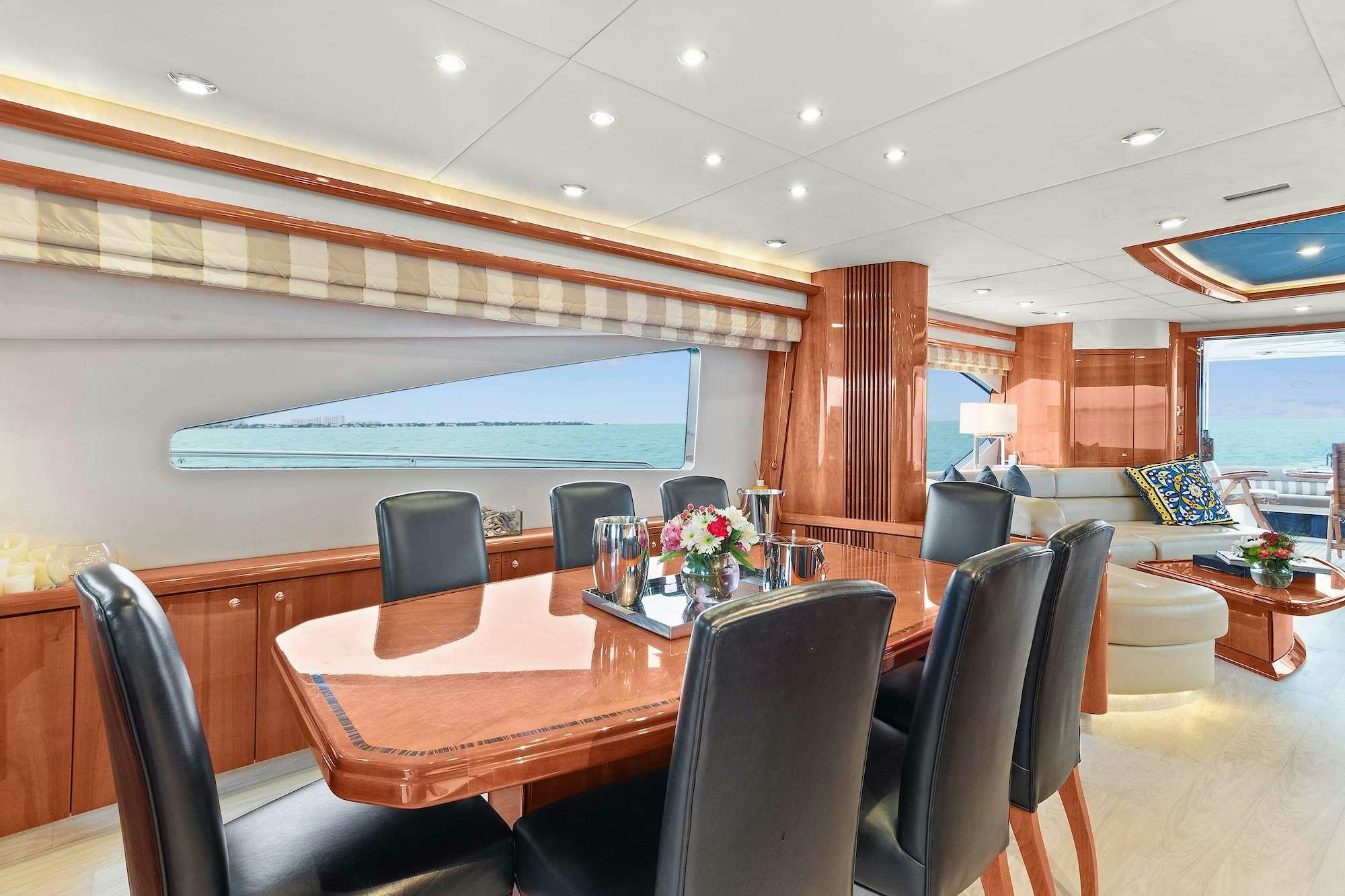 a room with tables and chairs aboard acqua alberti Yacht for Charter