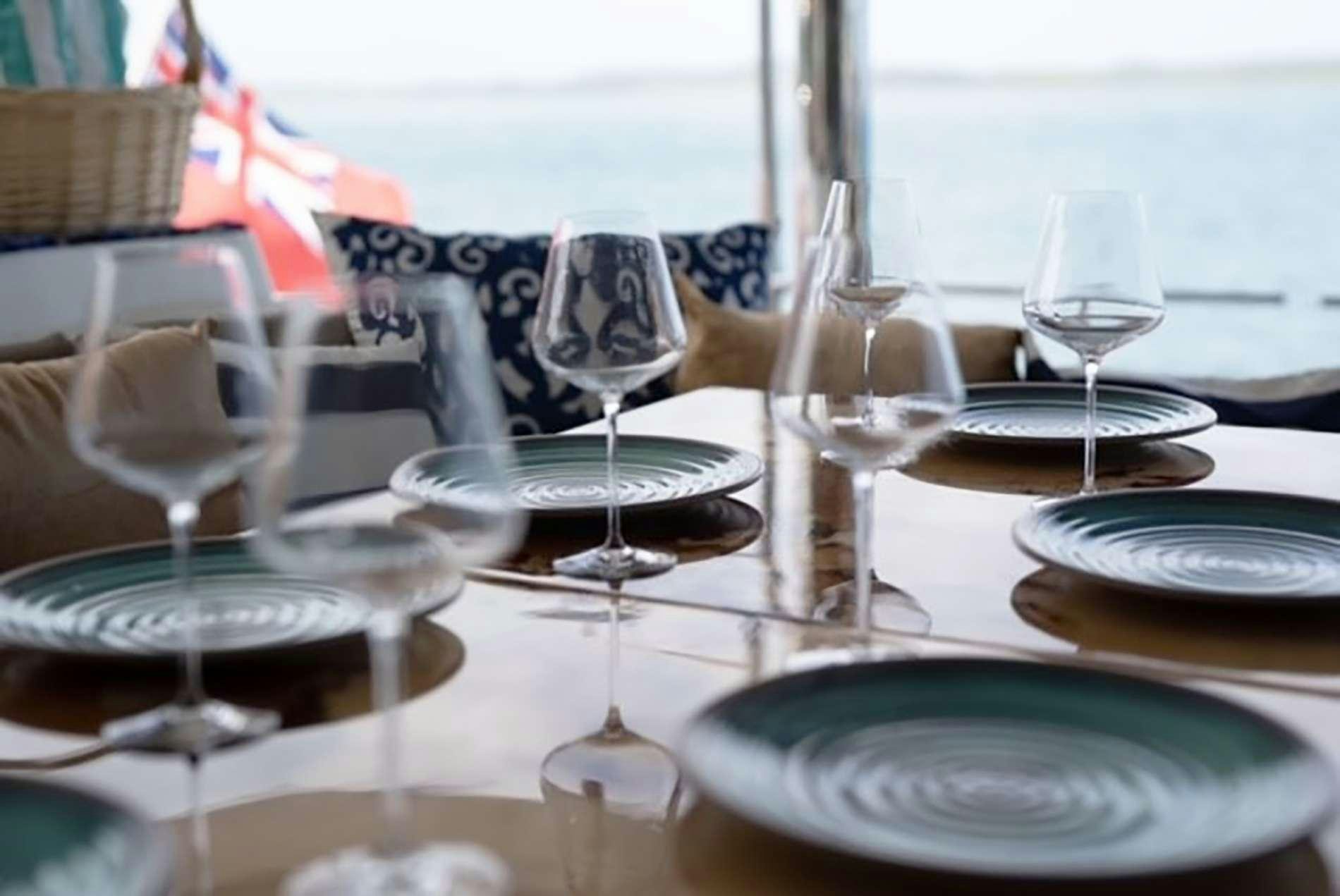 a table with plates and glasses on it aboard THE RECIPE Yacht for Charter