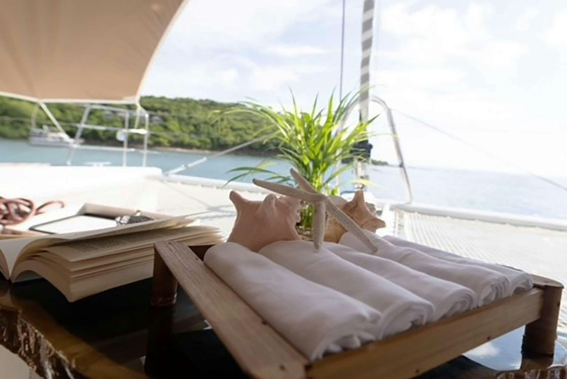 a bed with a white sheet and a plant on it aboard THE RECIPE Yacht for Charter