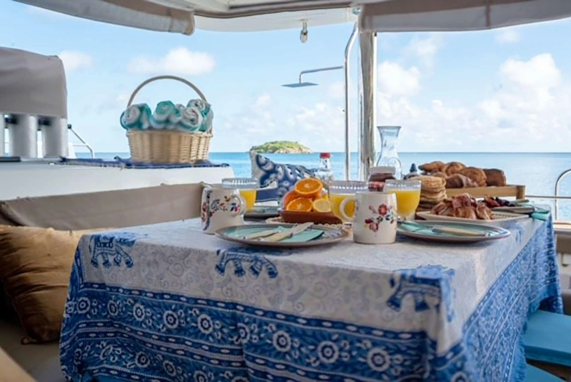 a table with plates and food on it aboard THE RECIPE Yacht for Charter