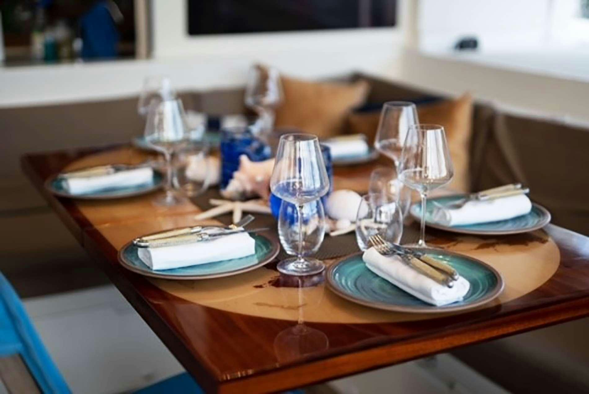 a table with plates and glasses aboard THE RECIPE Yacht for Charter