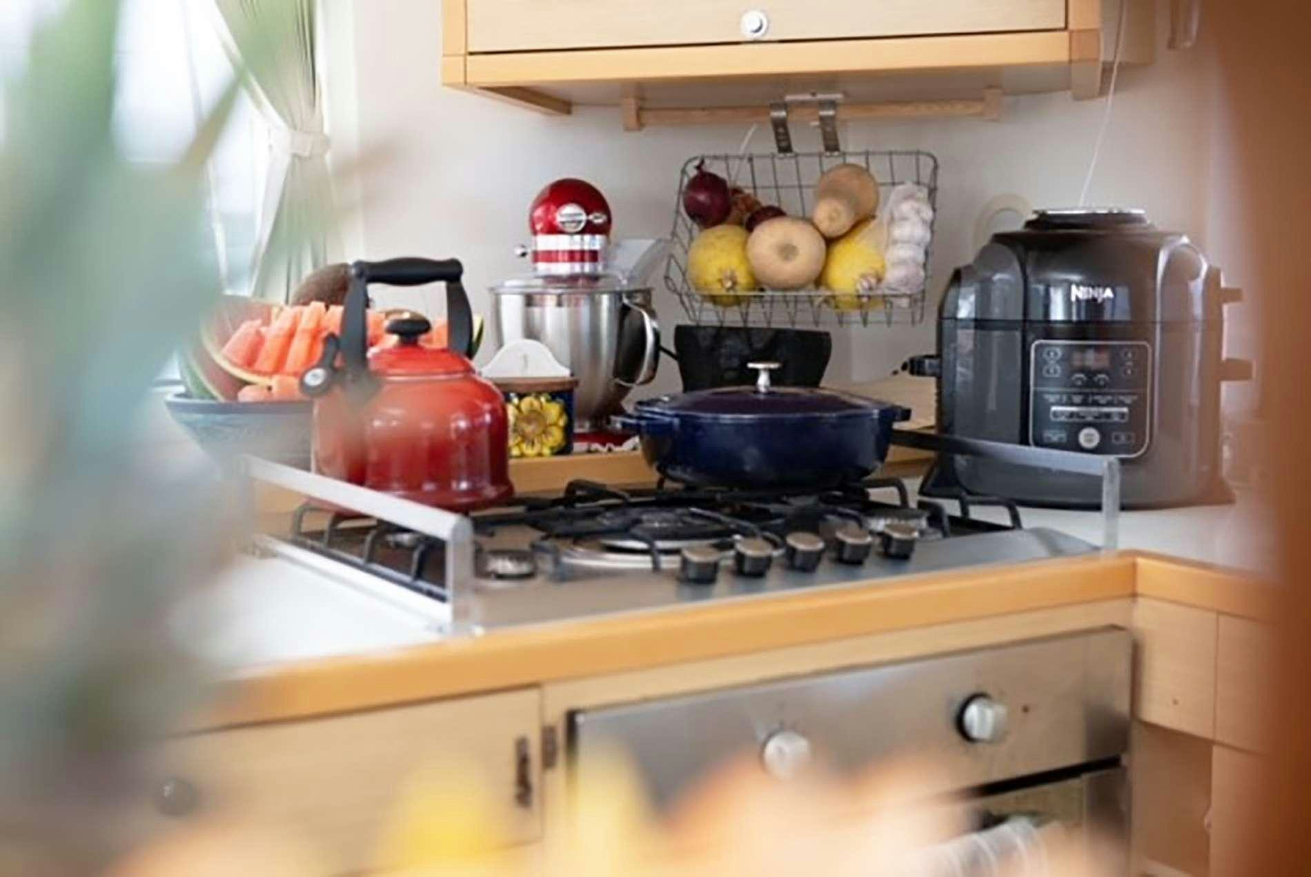 a kitchen with a stove and tea kettle on the stove aboard THE RECIPE Yacht for Charter