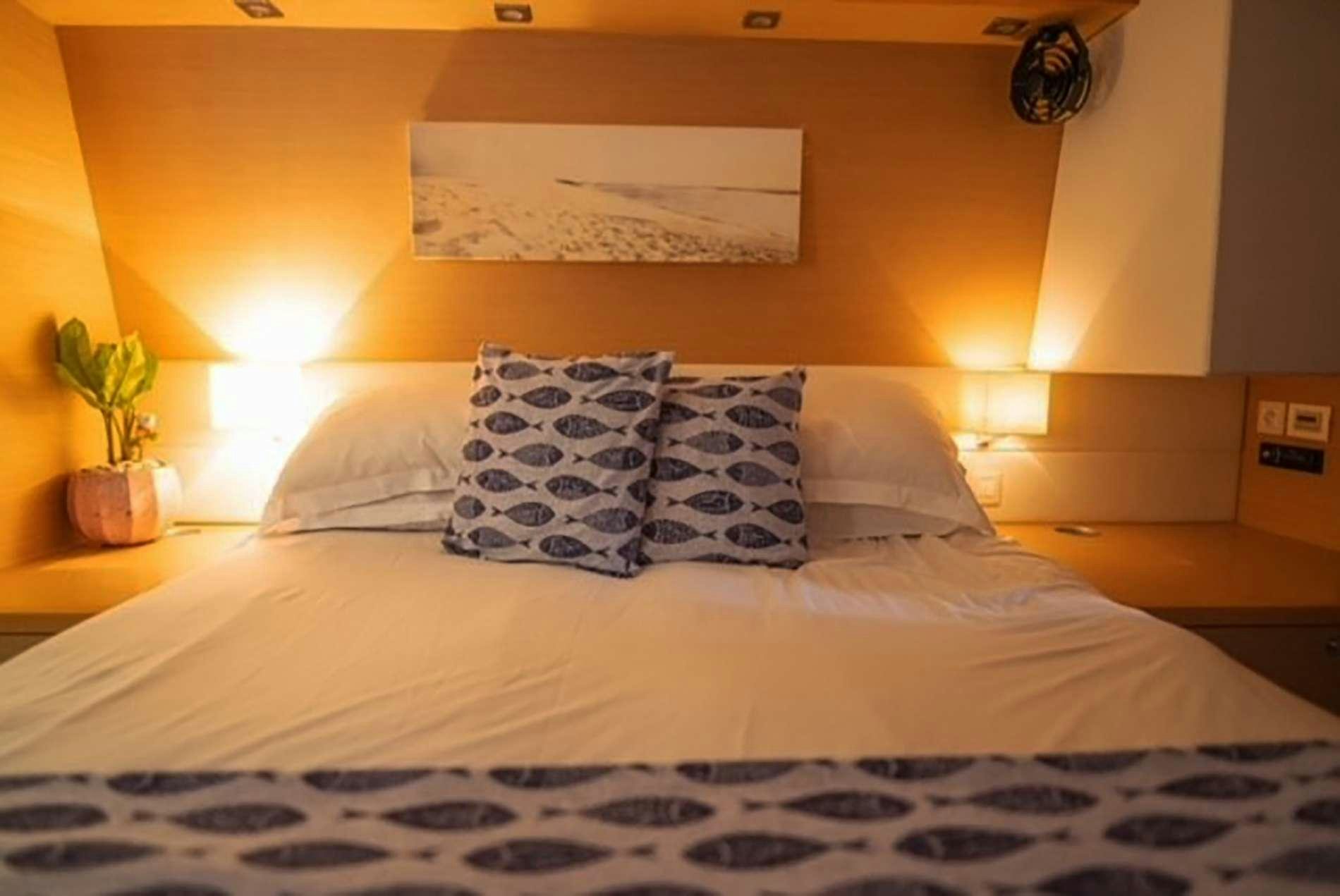 a bed with a white comforter and pillows aboard THE RECIPE Yacht for Charter