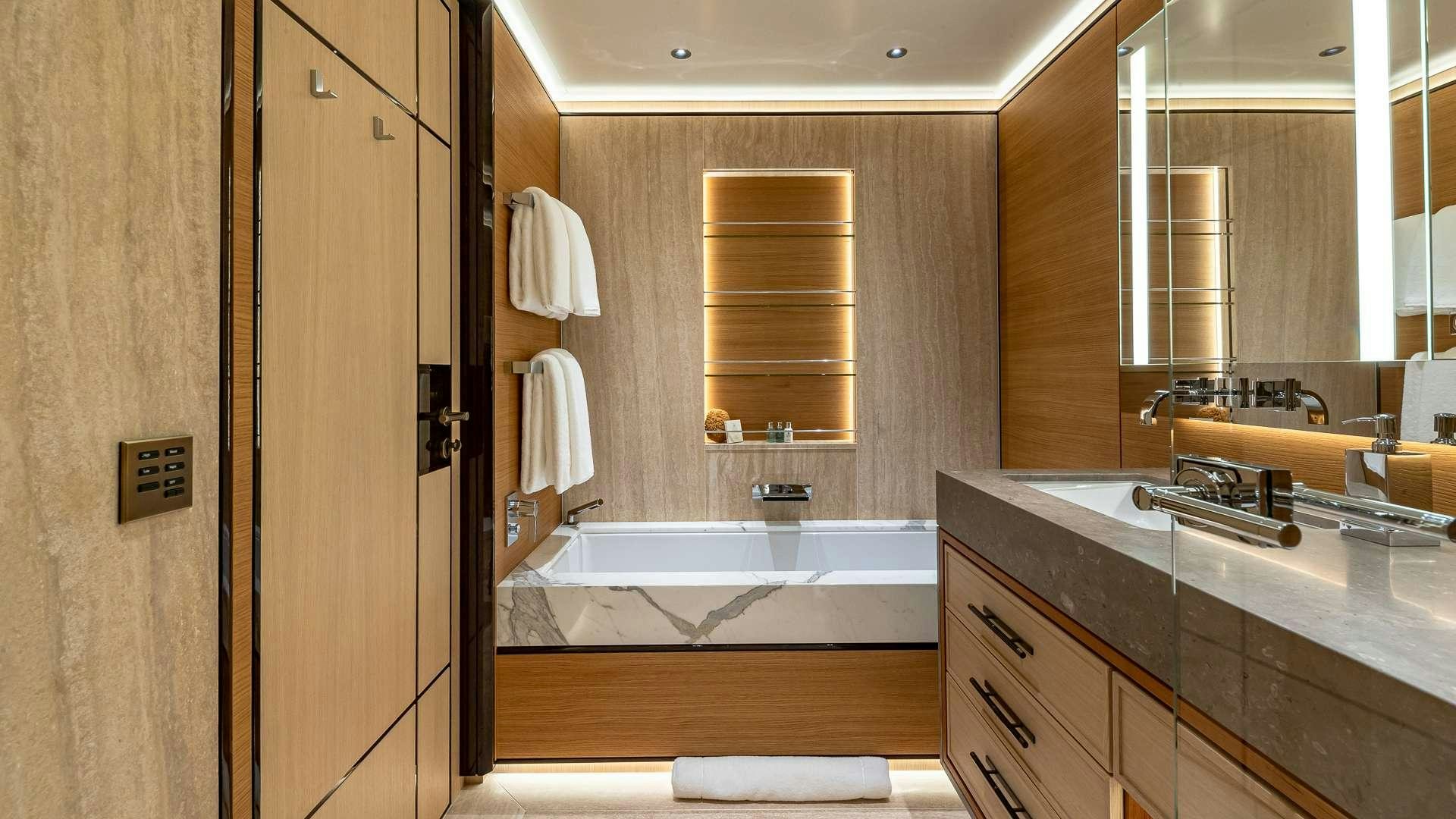 a bathroom with a tub sink and cabinets aboard TOP FIVE II Yacht for Charter