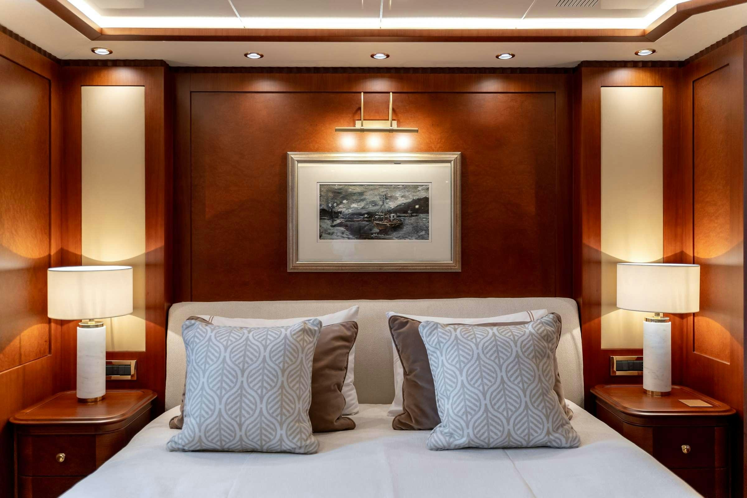 a bed with pillows and lamps aboard OCEANOS Yacht for Charter