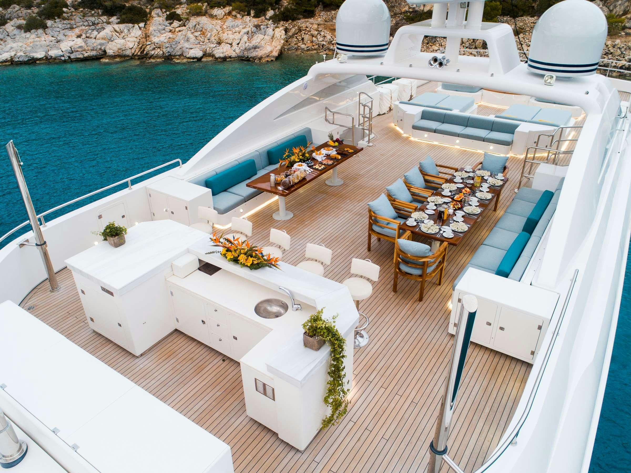 a deck with a pool and lounge chairs on it aboard OCEANOS Yacht for Charter