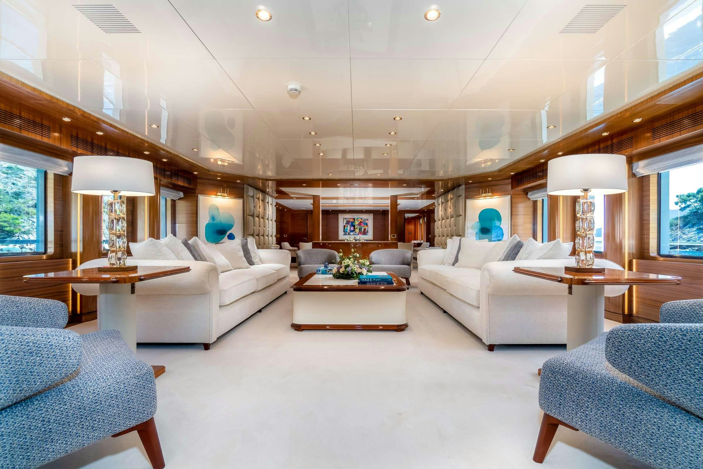 a living room with white furniture aboard OCEANOS Yacht for Charter