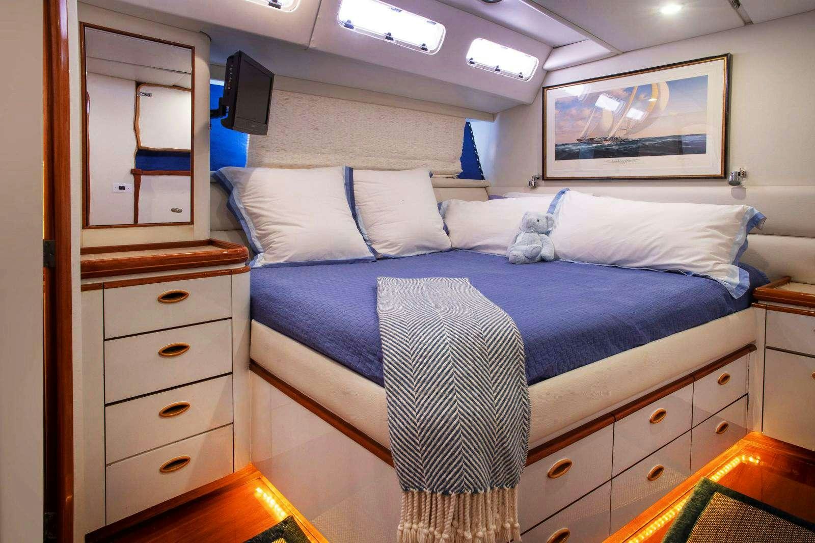 a bed with blue sheets aboard FALCON Yacht for Charter
