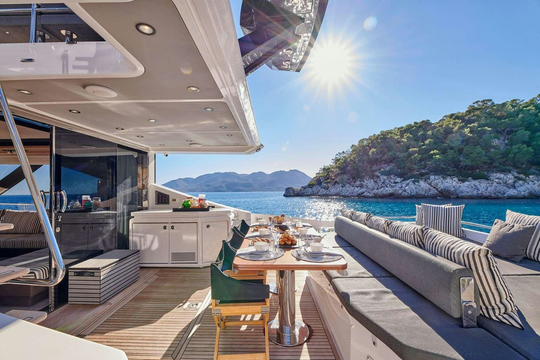 a deck with a table and chairs on it aboard ALKYONE Yacht for Charter