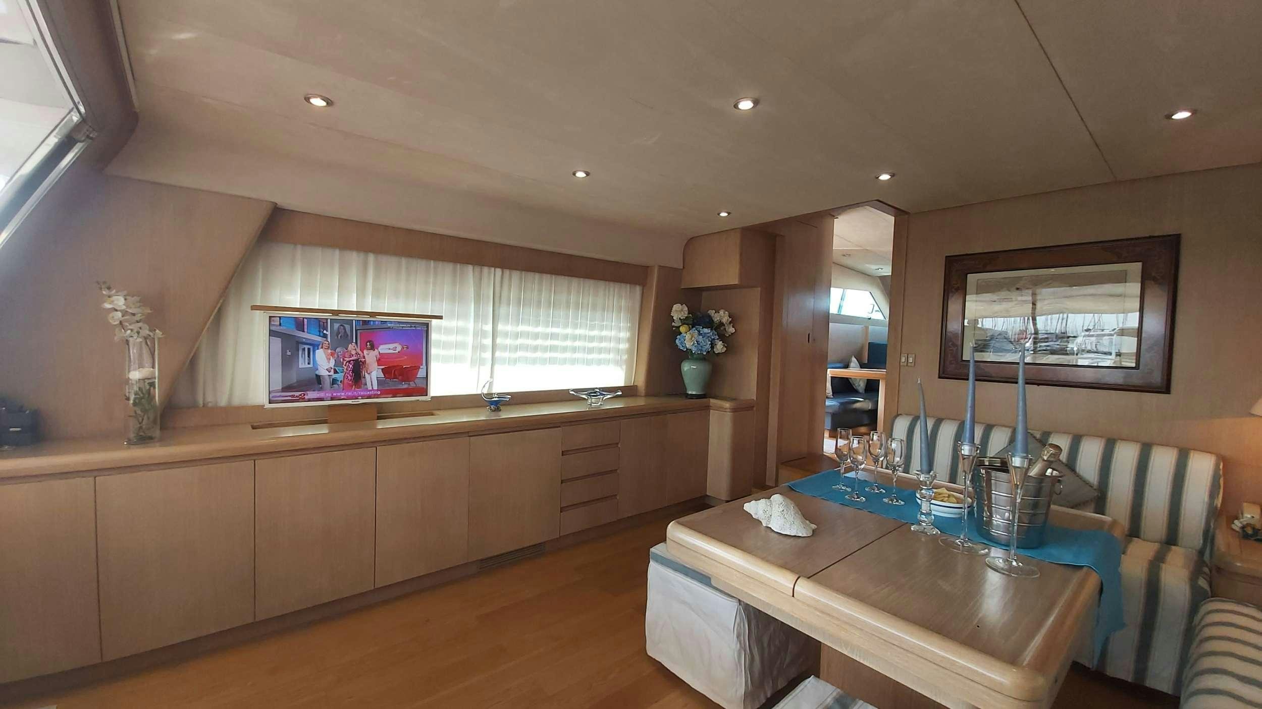 a living room with a table and tv aboard San Matteo Yacht for Charter