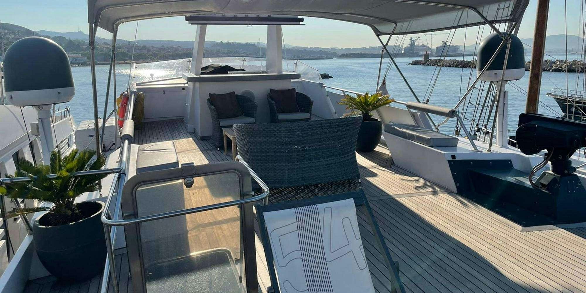 a deck with a table and chairs on it aboard SEA SEVEN Yacht for Charter