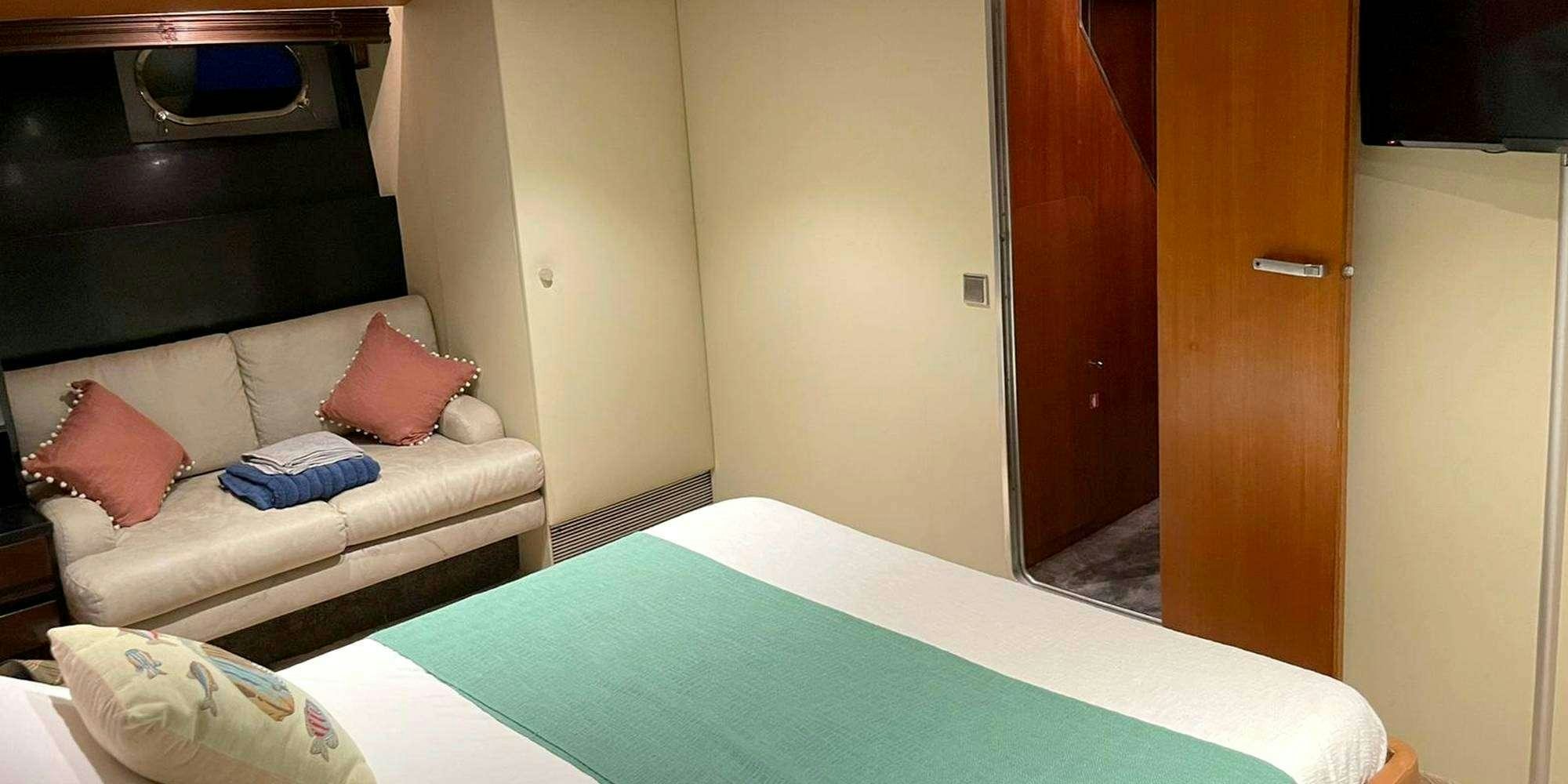 a room with a bed and a couch aboard SEA SEVEN Yacht for Charter