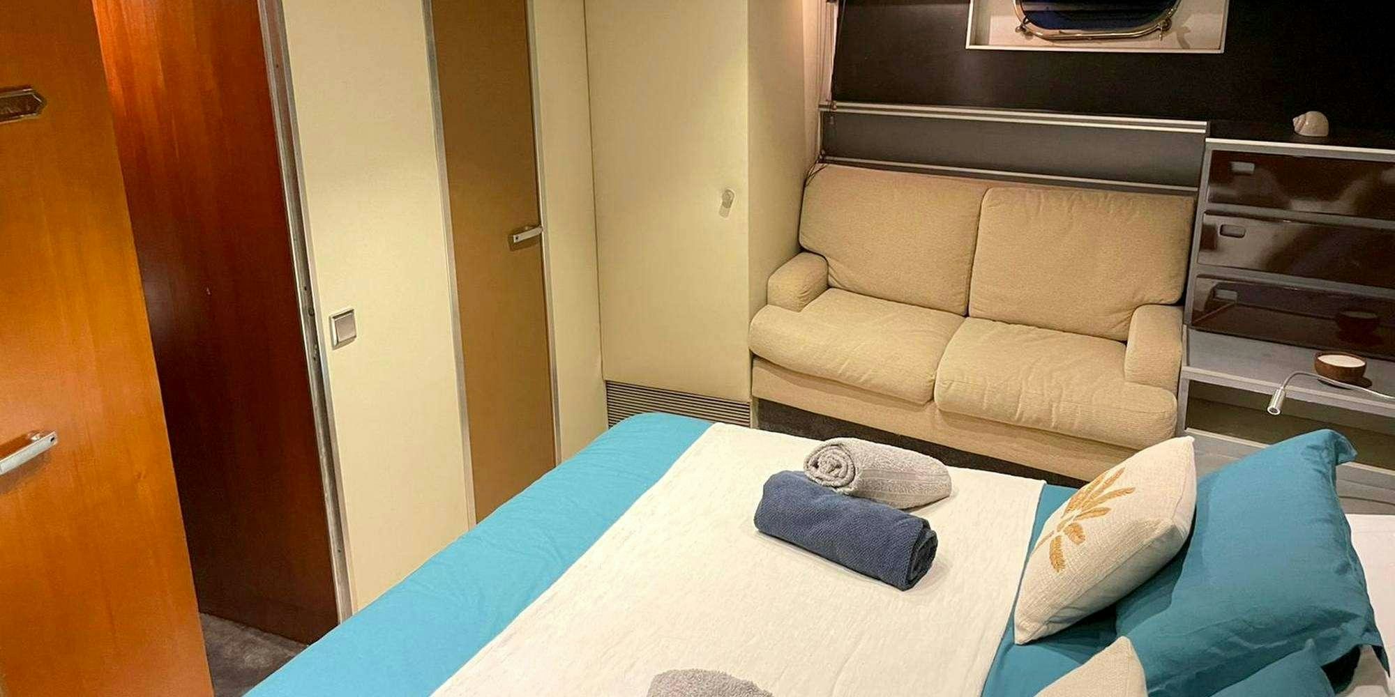 a couch and a chair in a room aboard SEA SEVEN Yacht for Charter