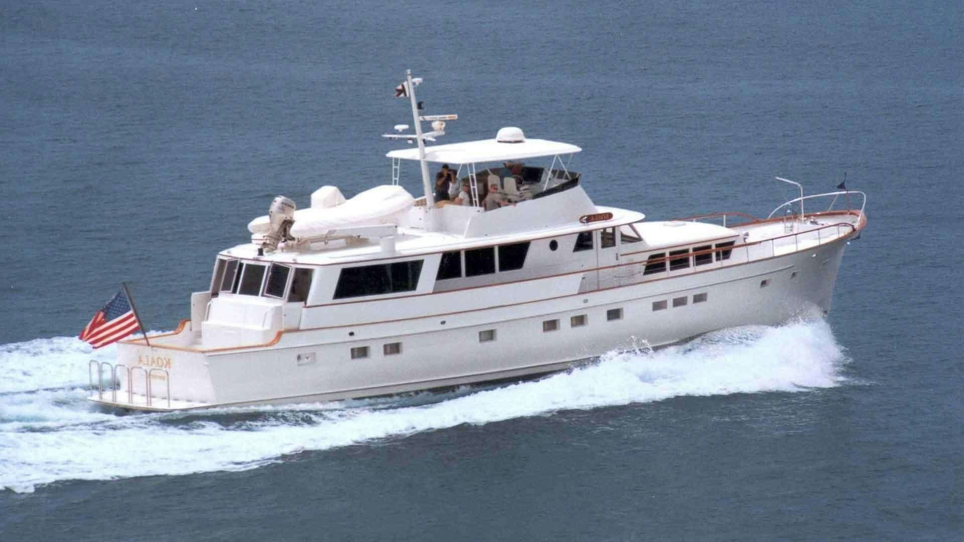 a large white ship with a flag on it aboard KOALA Yacht for Charter
