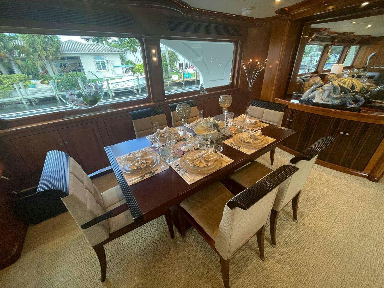 a dining table with chairs and a large window aboard SCOTT FREE Yacht for Charter