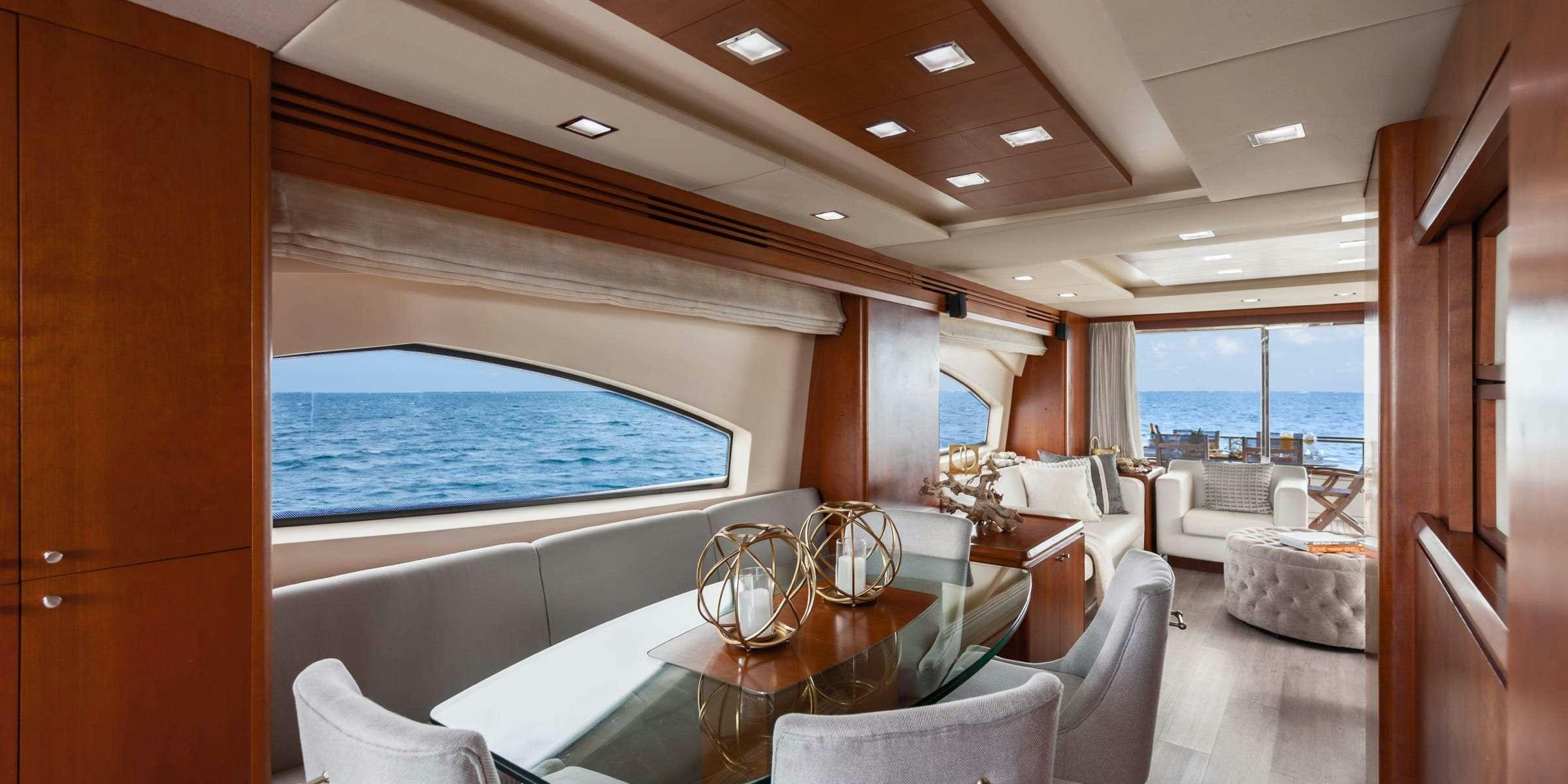 a room with a table chairs and a large blue ocean aboard TRUCO II Yacht for Charter