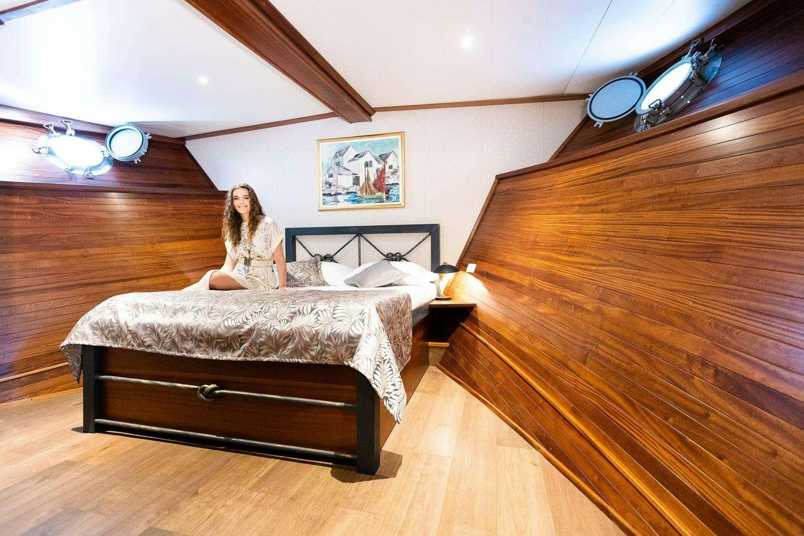 a person sitting on a bed aboard GALLANT Yacht for Charter