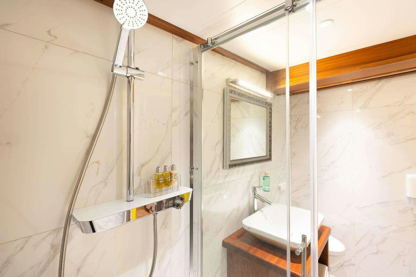 a bathroom with a tub and shower aboard GALLANT Yacht for Charter