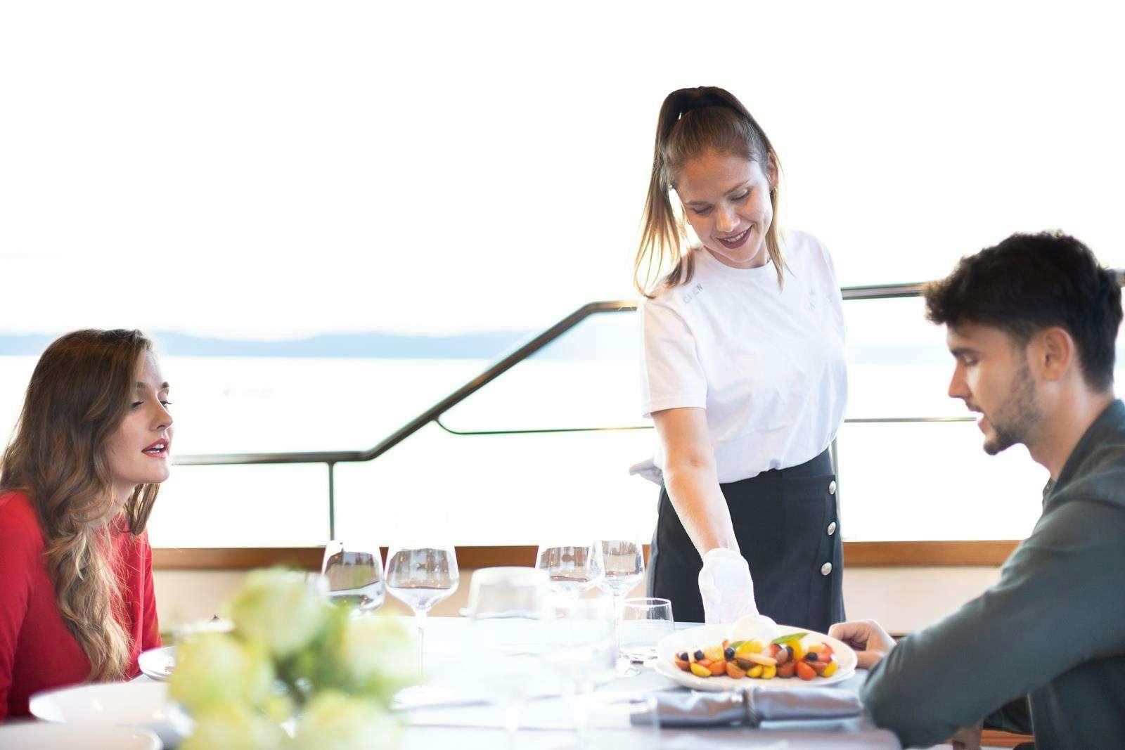a woman pouring wine into a glass aboard GALLANT Yacht for Charter