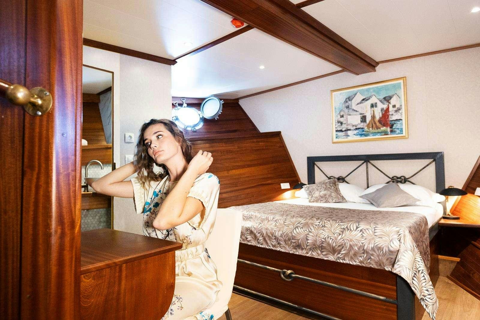 a person in a dress in a bedroom aboard GALLANT Yacht for Charter