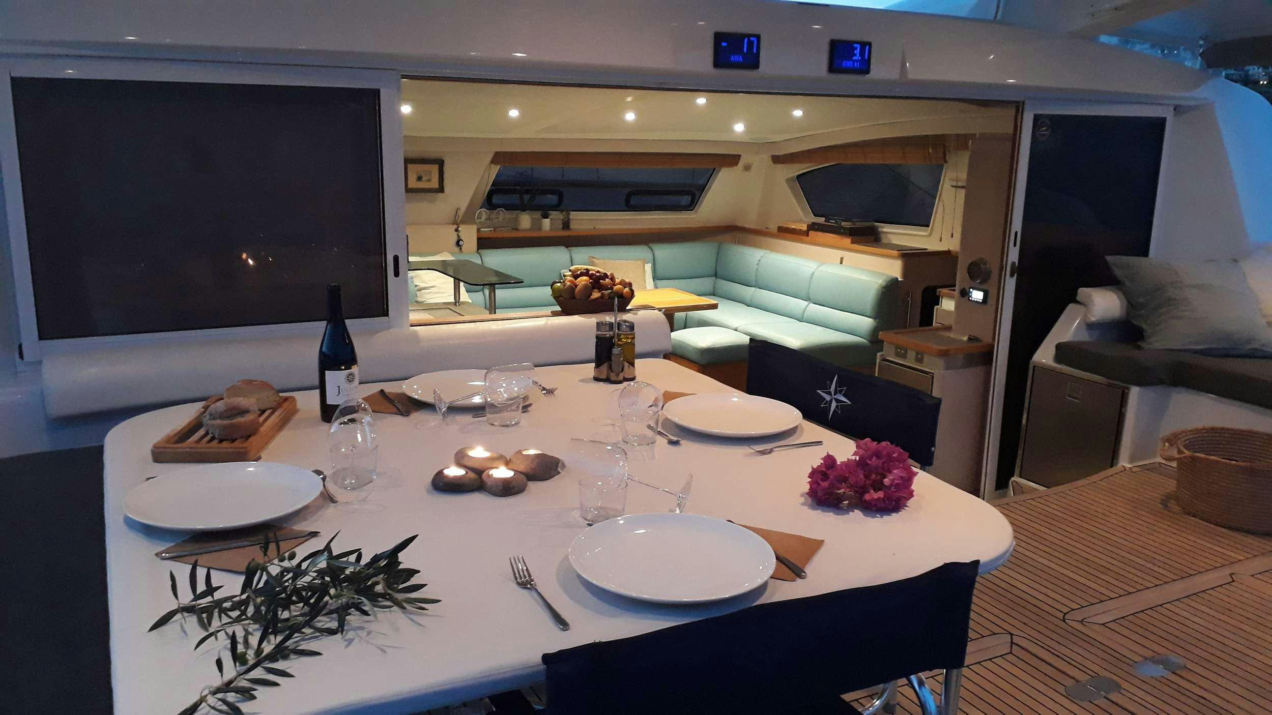 a table with plates and wine bottles aboard STADIUM Yacht for Charter