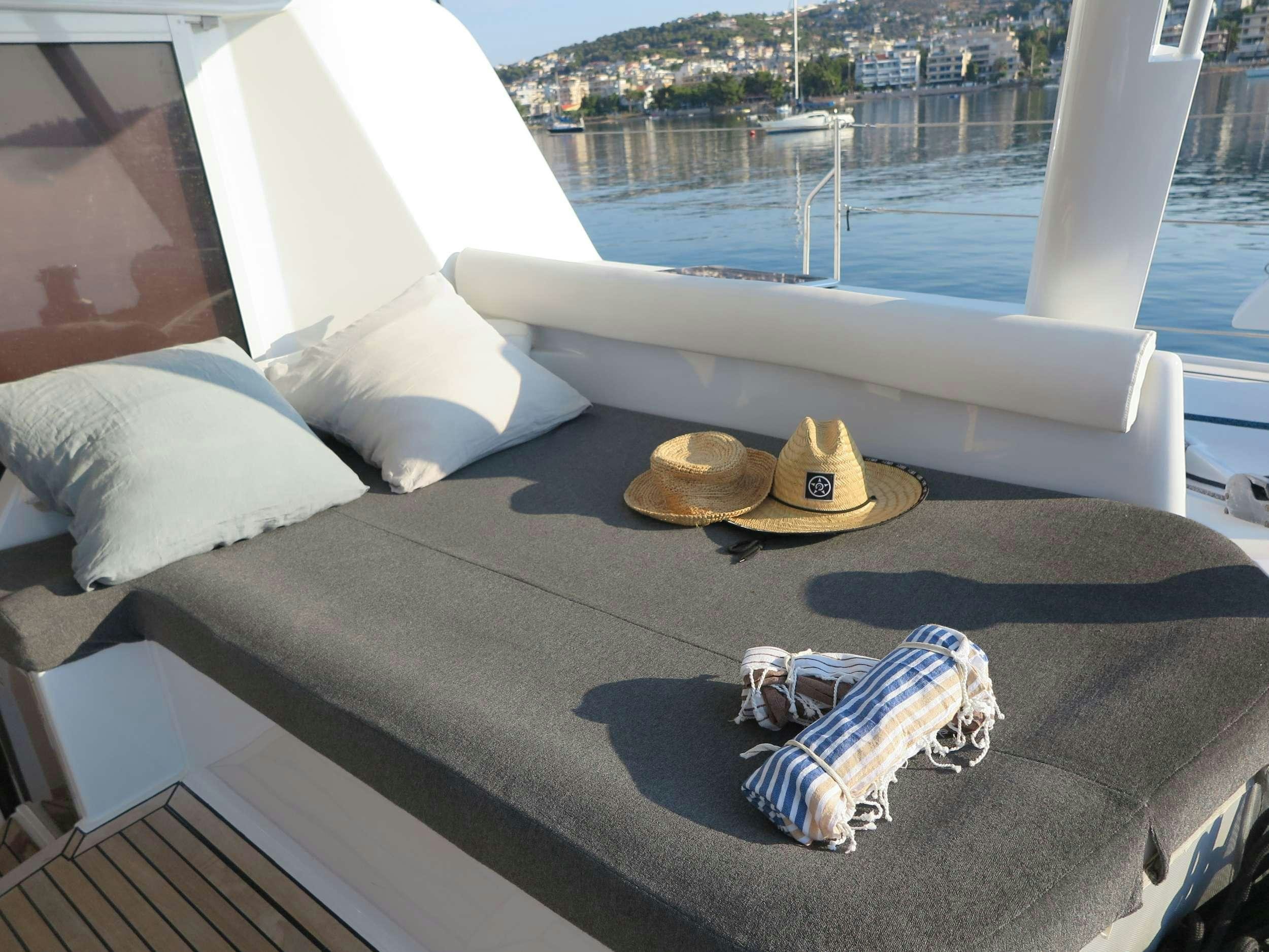 a hat and sunglasses on a bed aboard STADIUM Yacht for Charter