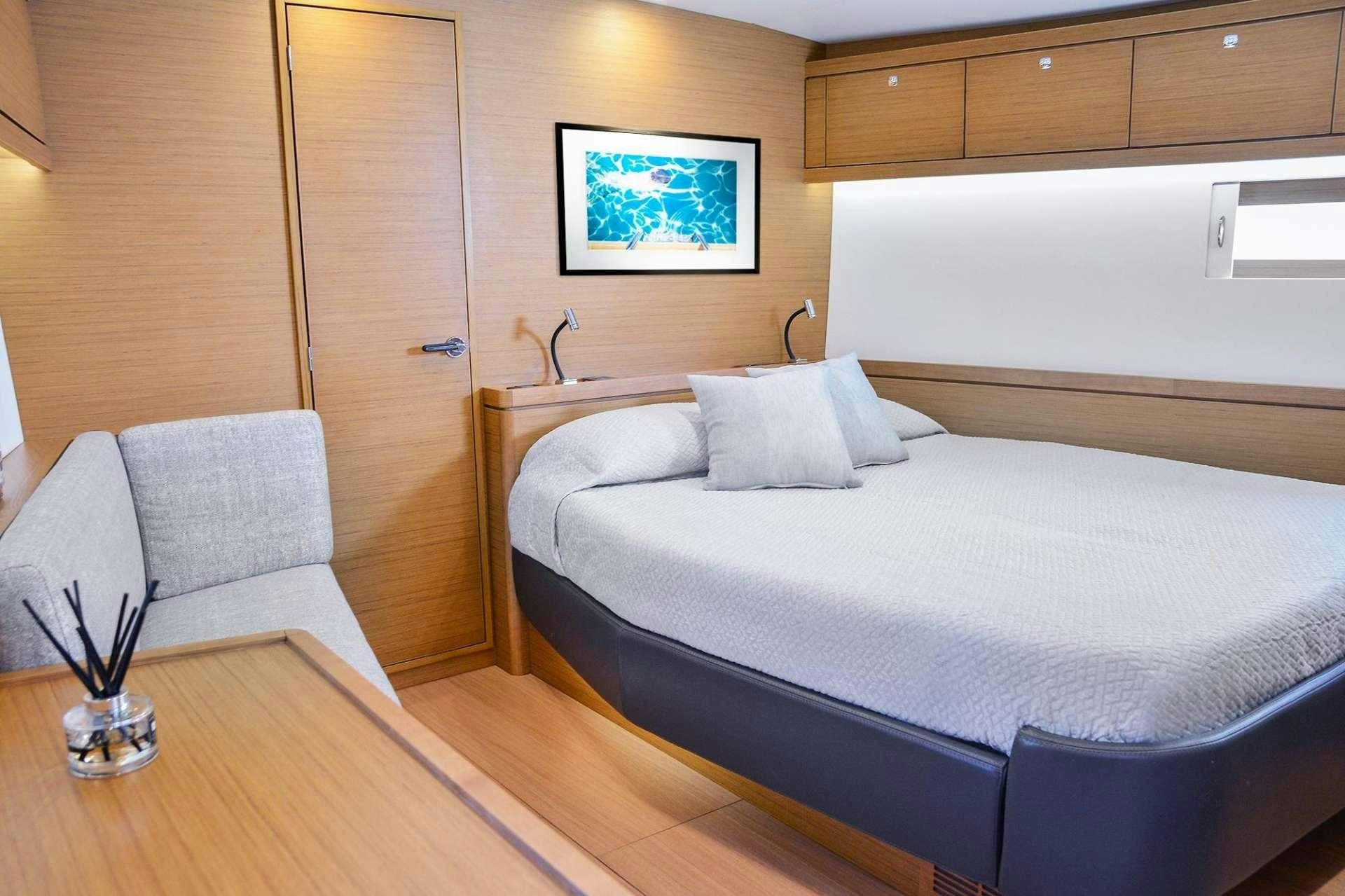a room with a bed and a chair aboard SOPHIA Yacht for Charter