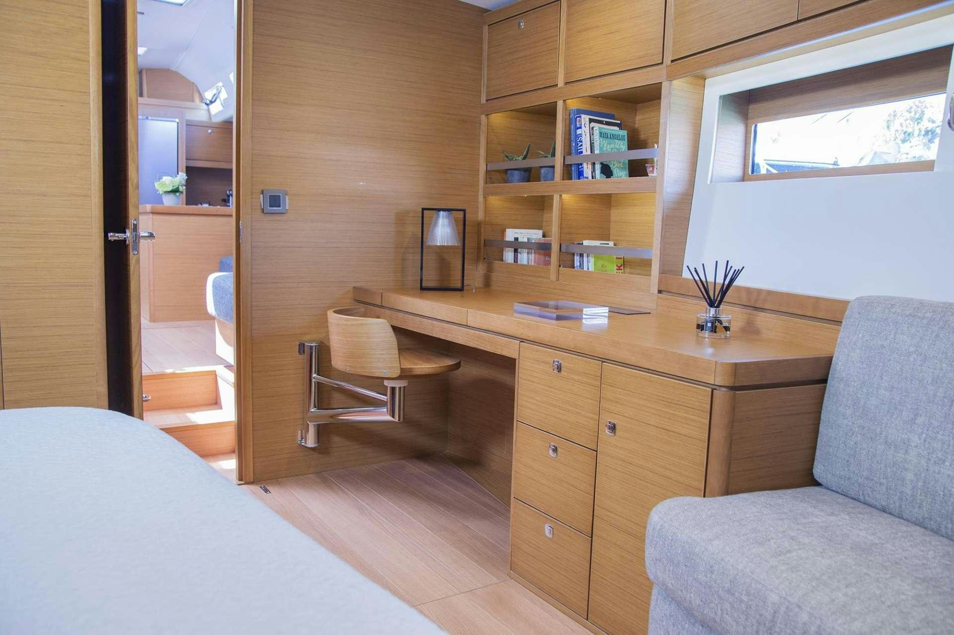 a bedroom with a desk and a bed aboard SOPHIA Yacht for Charter