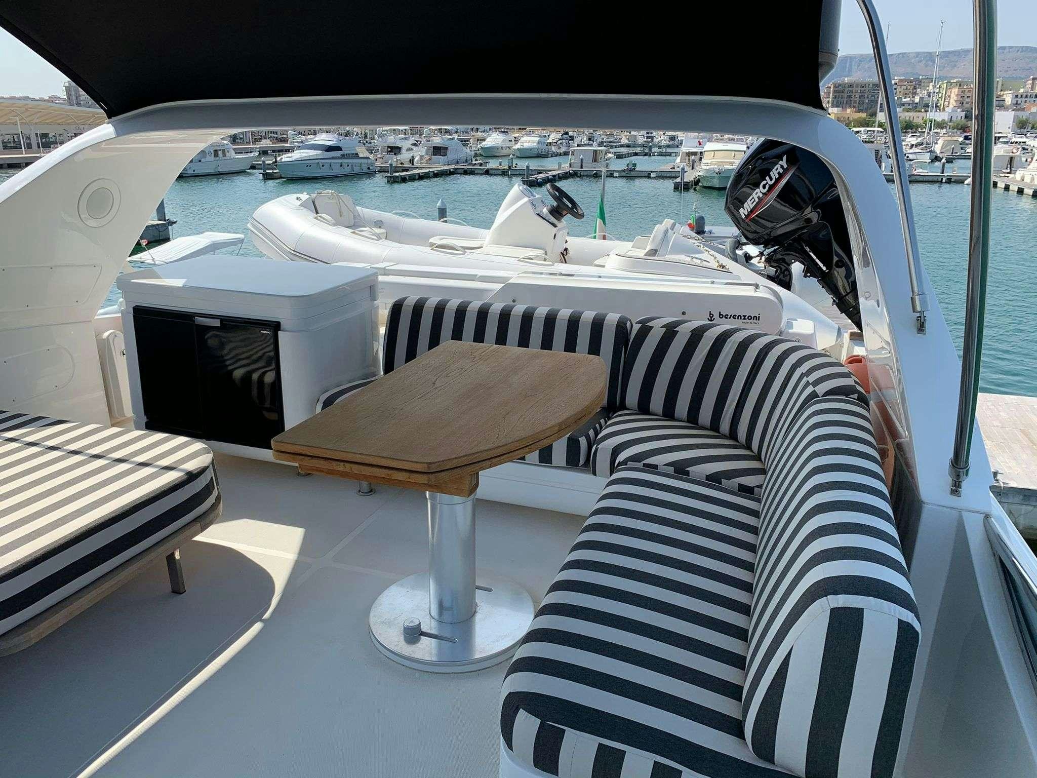 a deck with a table and chairs on it aboard SERENITY III Yacht for Charter