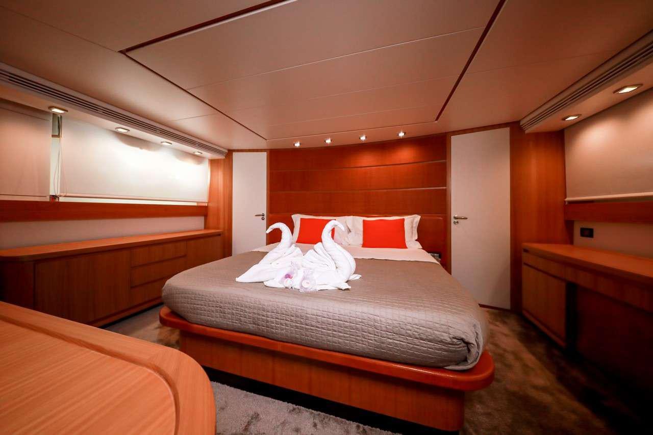 a room with a bed and a desk aboard SERENITY III Yacht for Charter