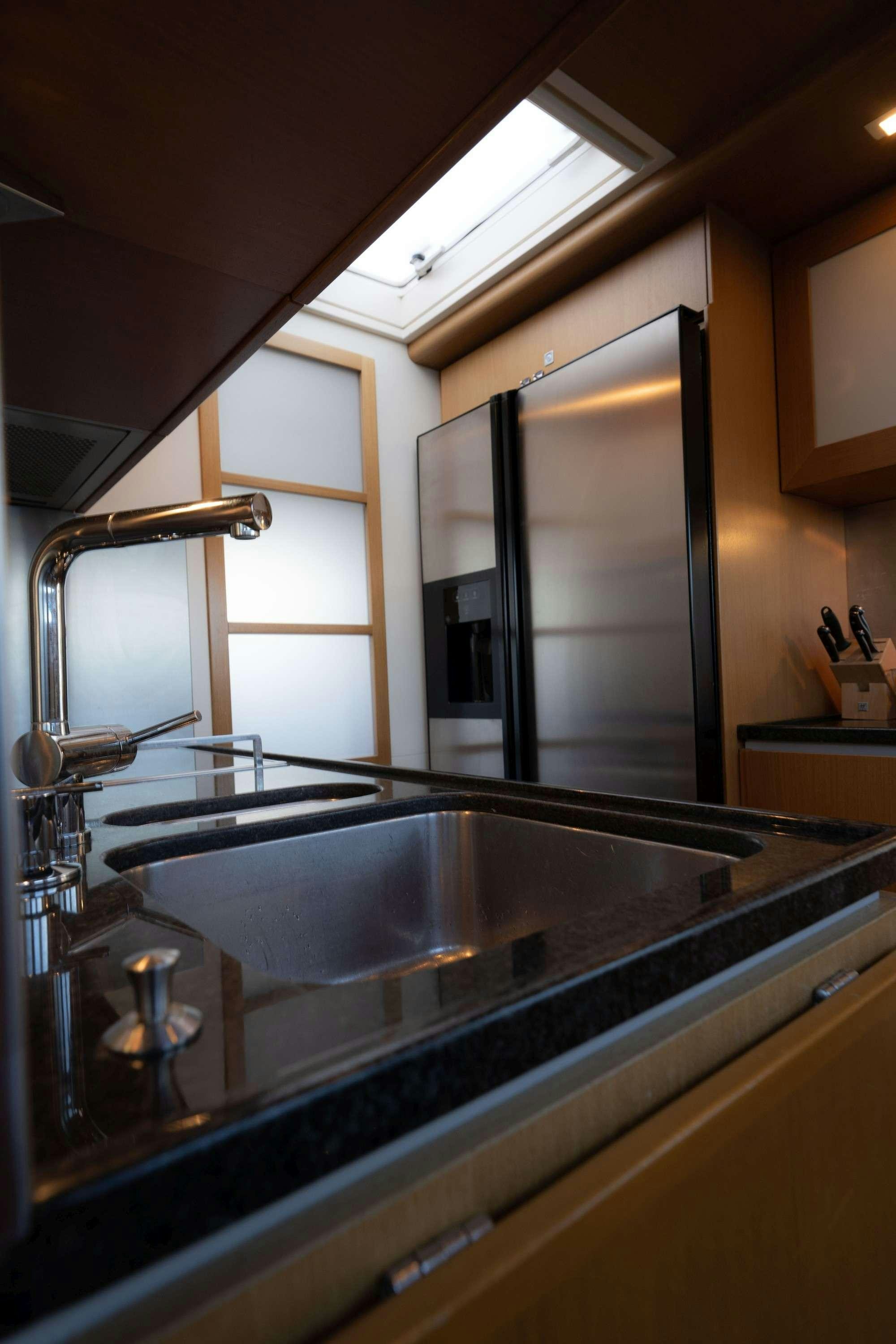 a kitchen with a sink and a large mirror aboard NINETEEN Yacht for Charter