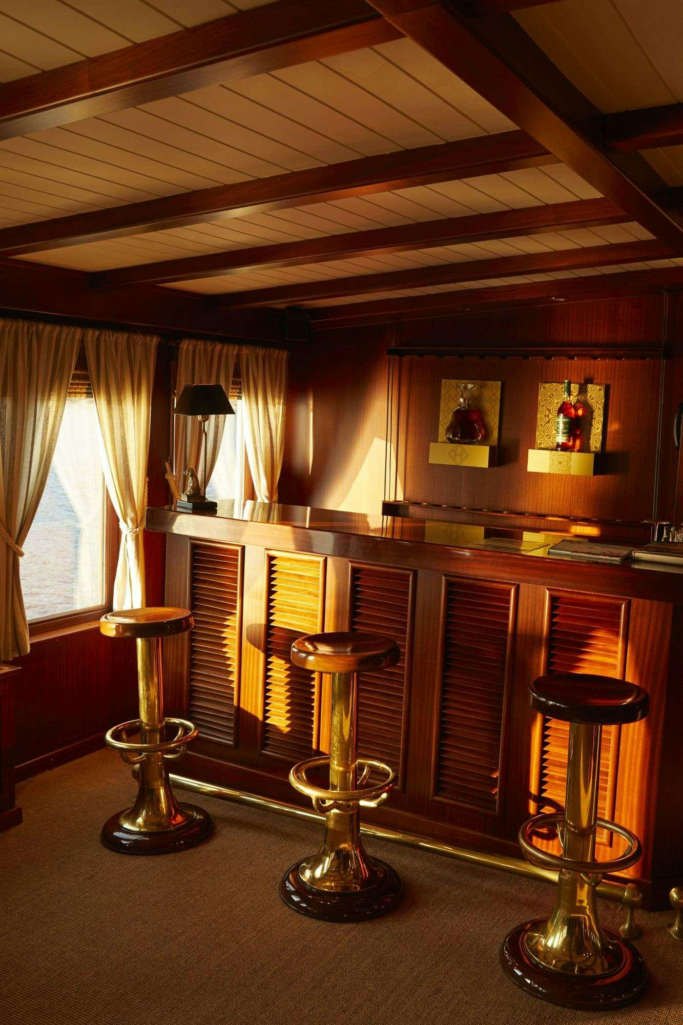 a bar with a bar and stools aboard HALAS 71 Yacht for Charter