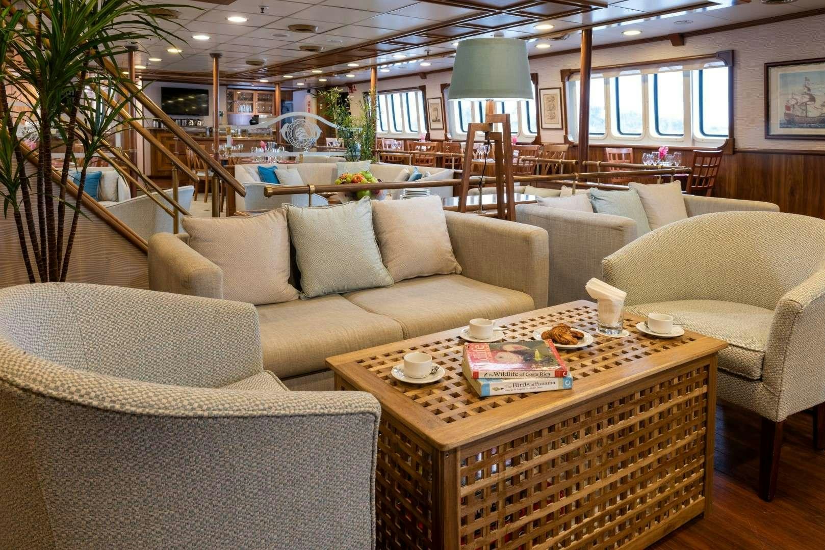 a living room with couches and a table aboard PAN ORAMA Yacht for Charter