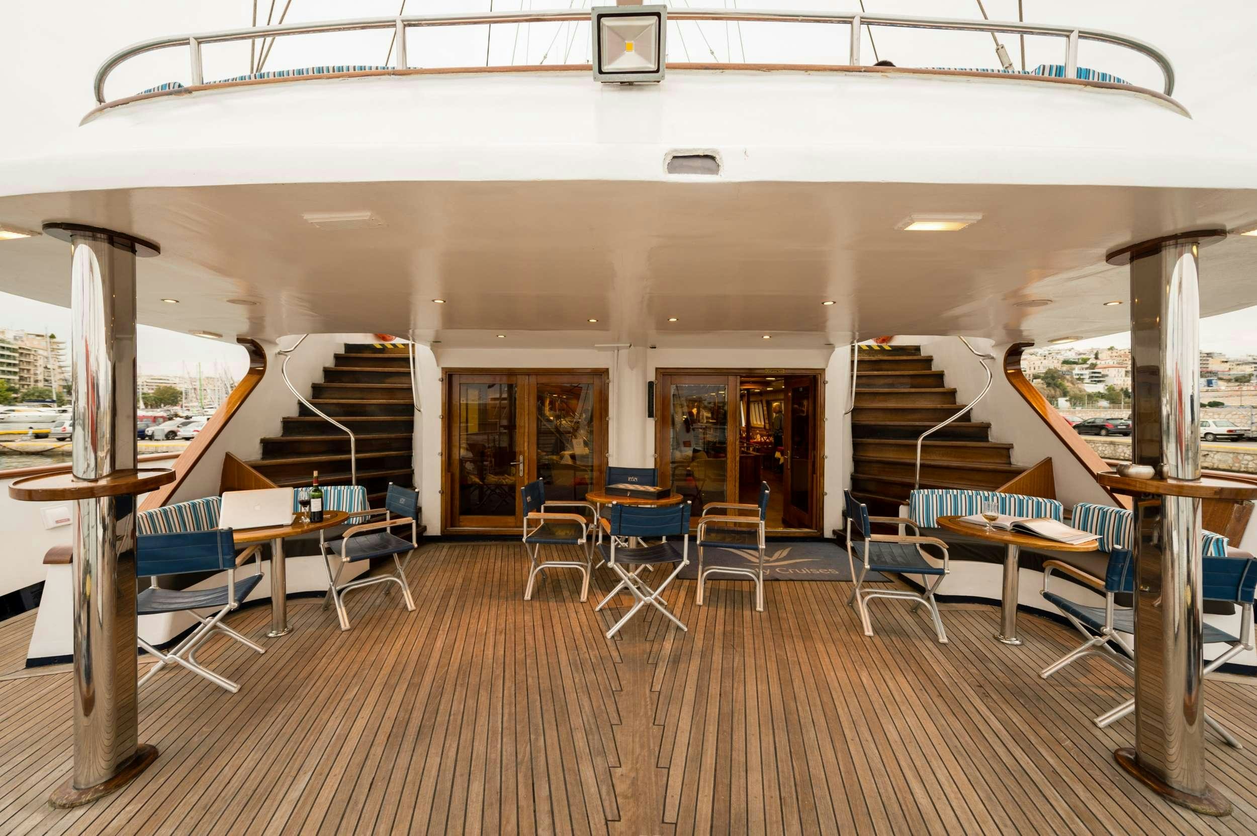 a room with tables and chairs aboard PAN ORAMA Yacht for Charter