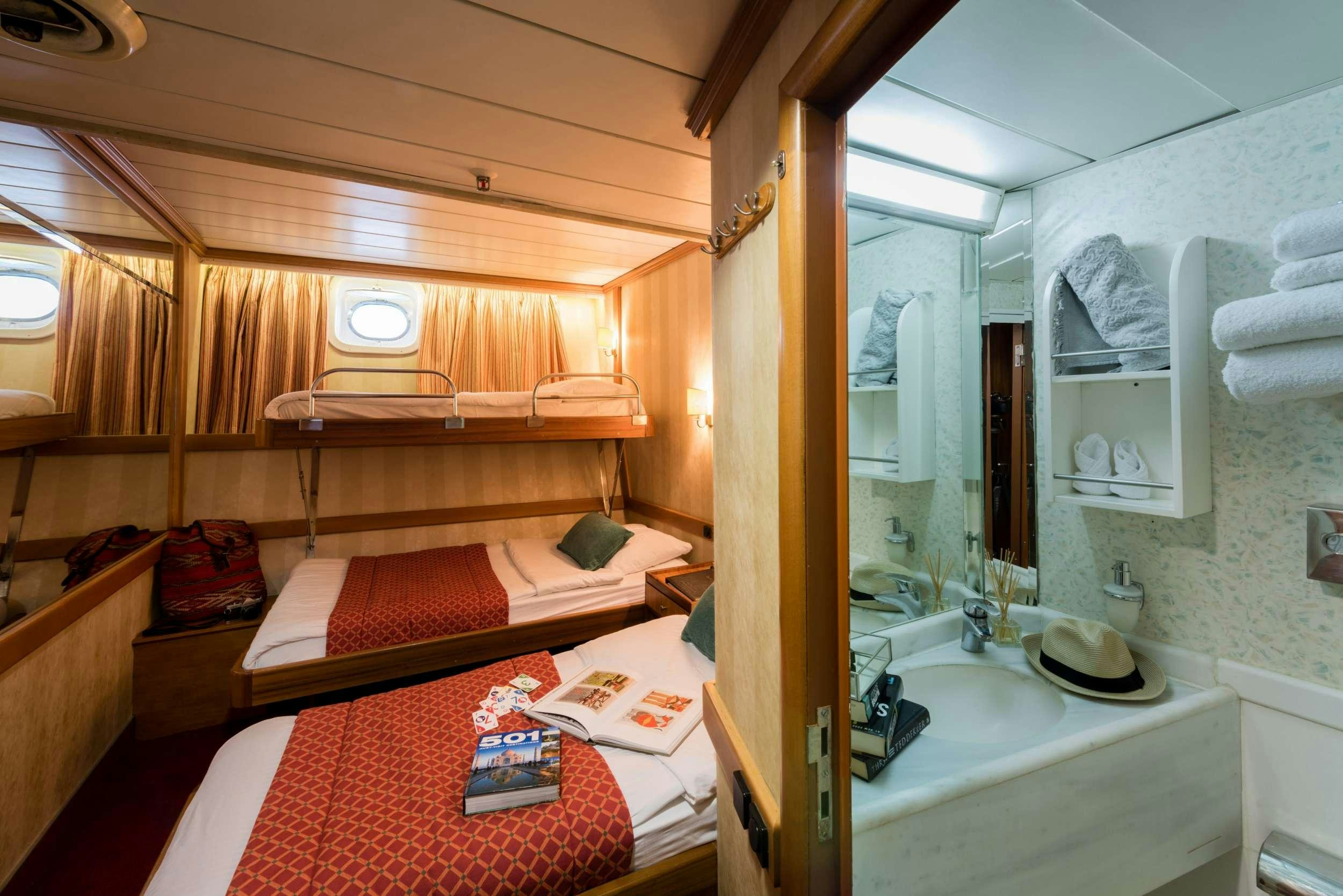 a room with a bed and a mirror aboard PAN ORAMA Yacht for Charter