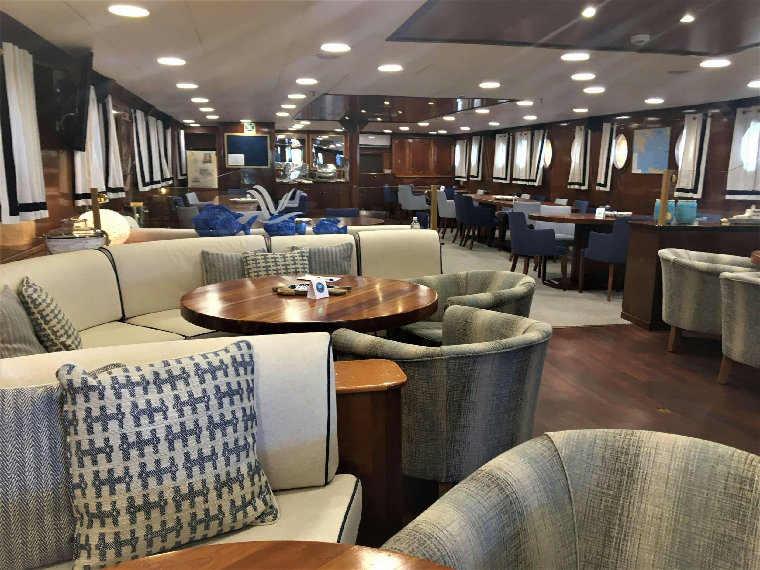 a room with a table and chairs aboard GALILEO Yacht for Charter