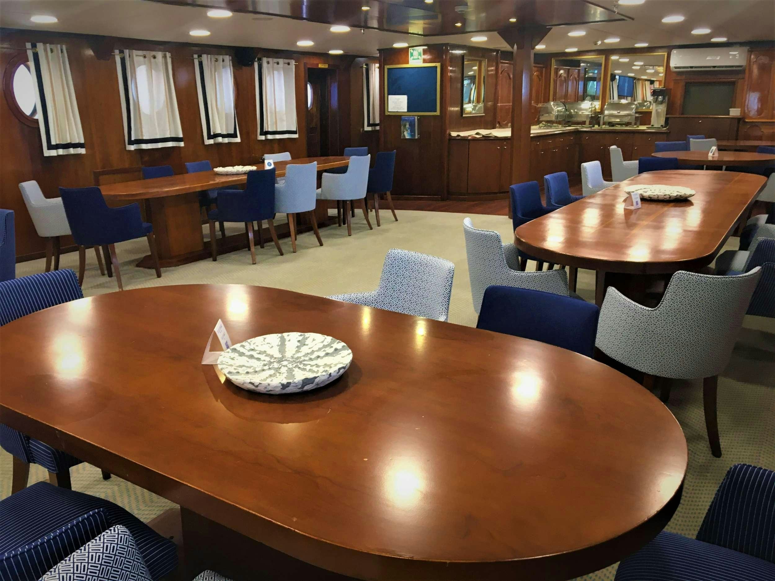 a restaurant with tables and chairs aboard GALILEO Yacht for Charter