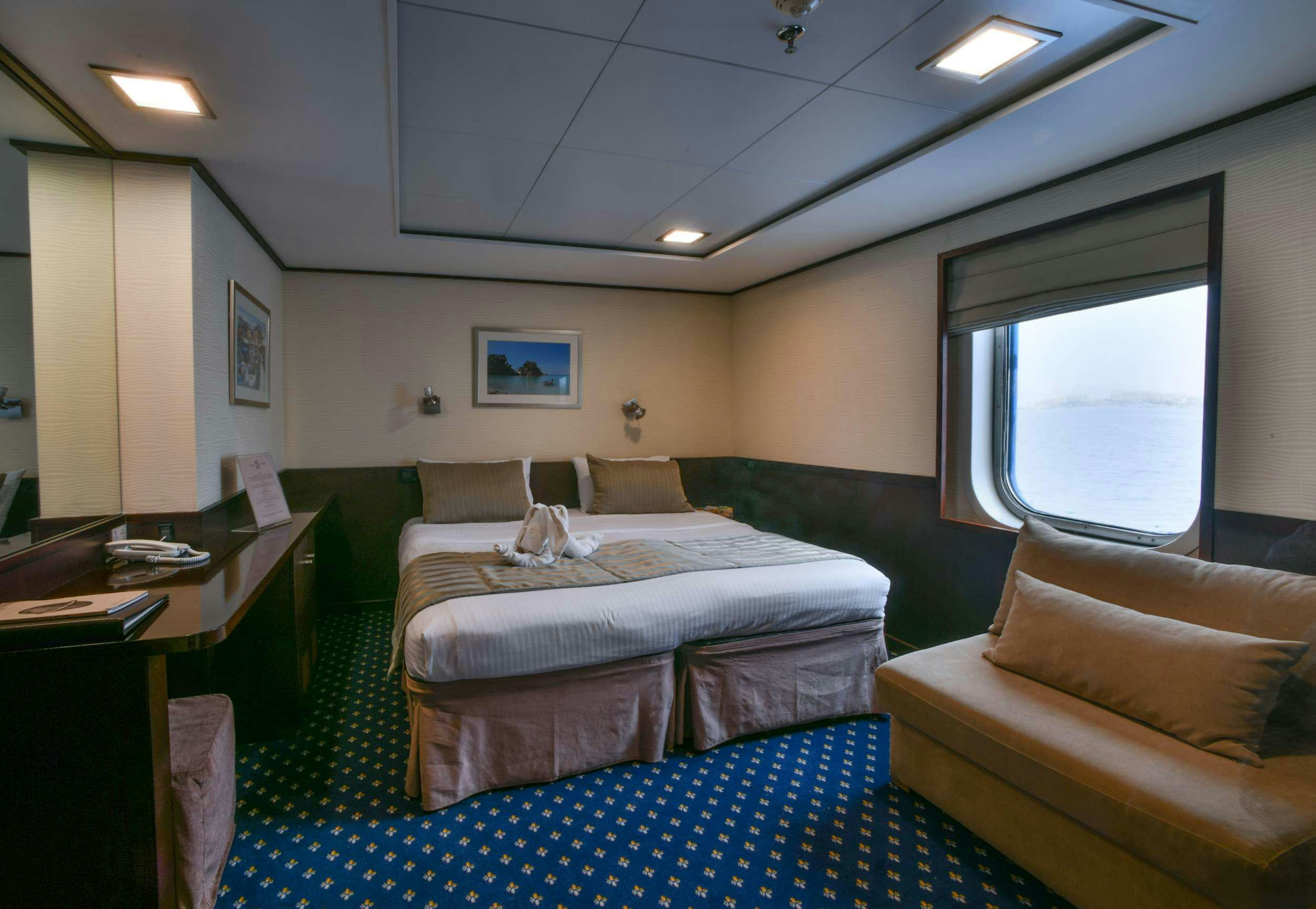 a bedroom with a bed and a desk aboard HARMONY V Yacht for Charter