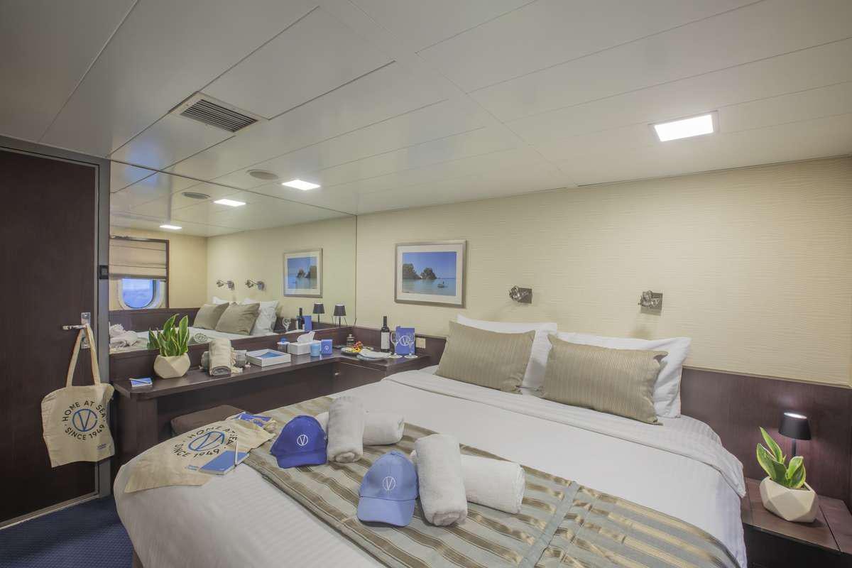 a bedroom with a bed and a desk aboard HARMONY V Yacht for Charter
