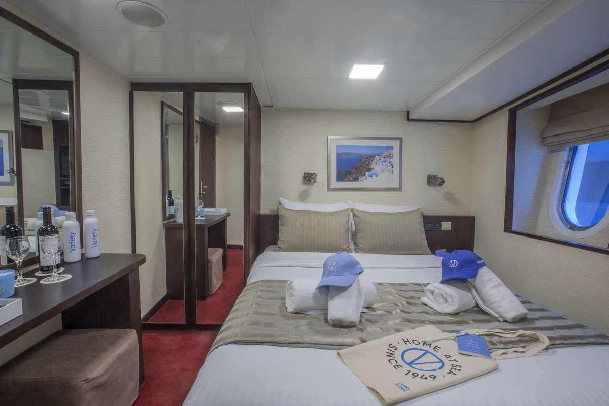 a hotel room with a bed and a desk aboard HARMONY V Yacht for Charter