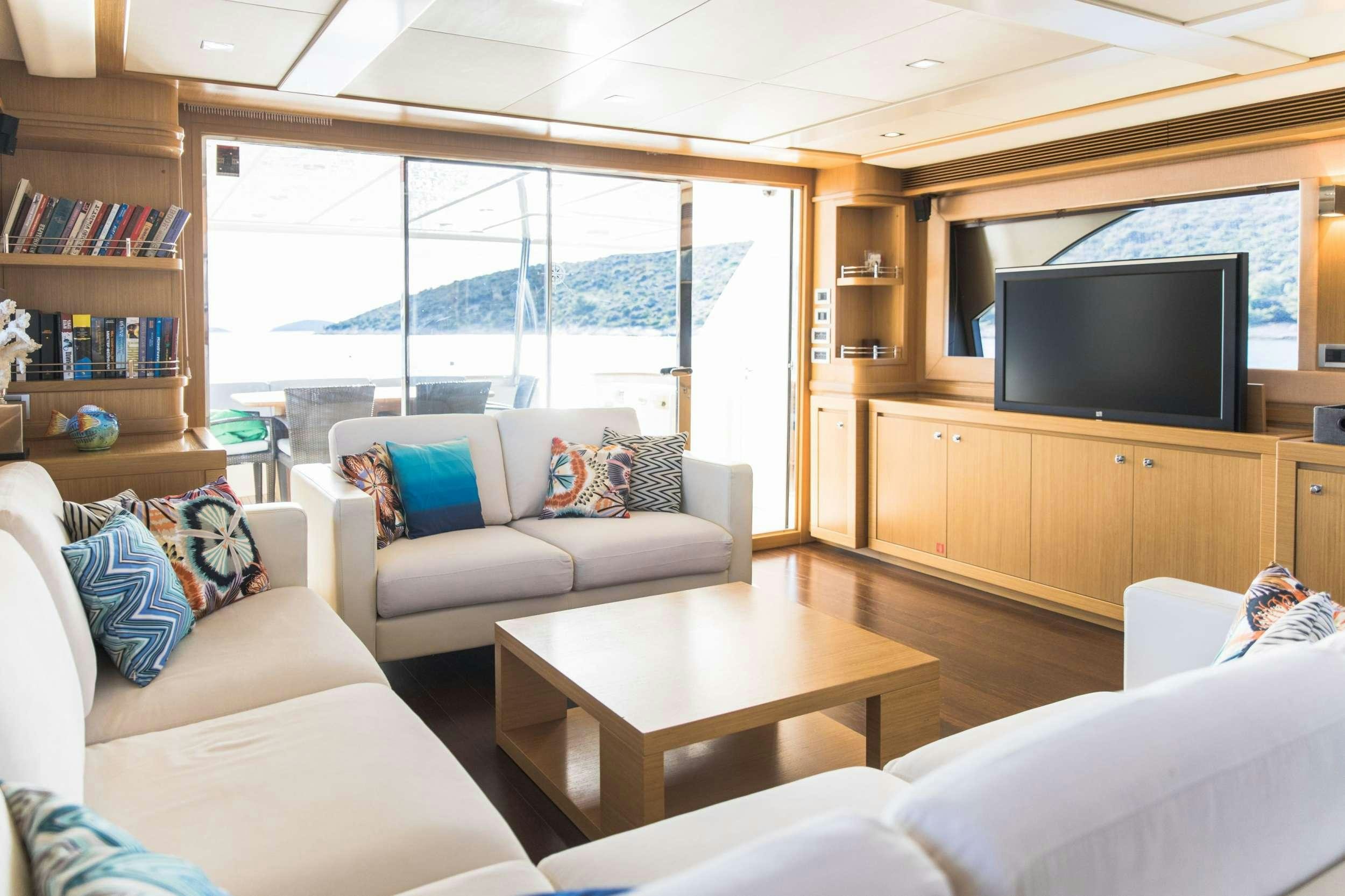a living room with a tv and couches aboard FRIEND'S BOAT Yacht for Charter