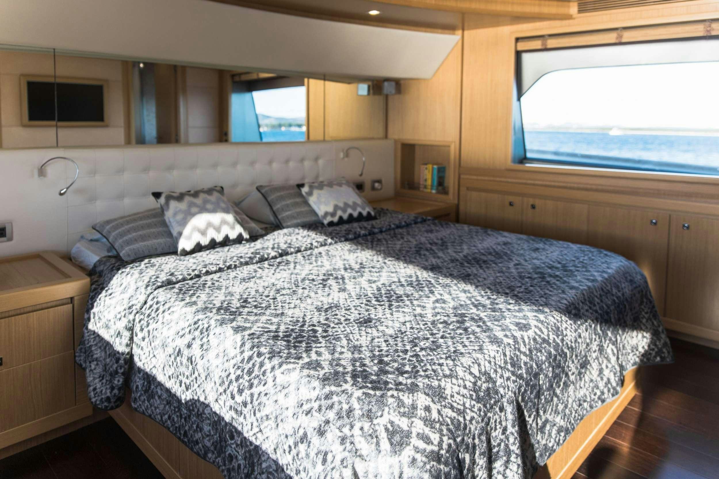 a bed with a blue comforter aboard FRIEND'S BOAT Yacht for Charter