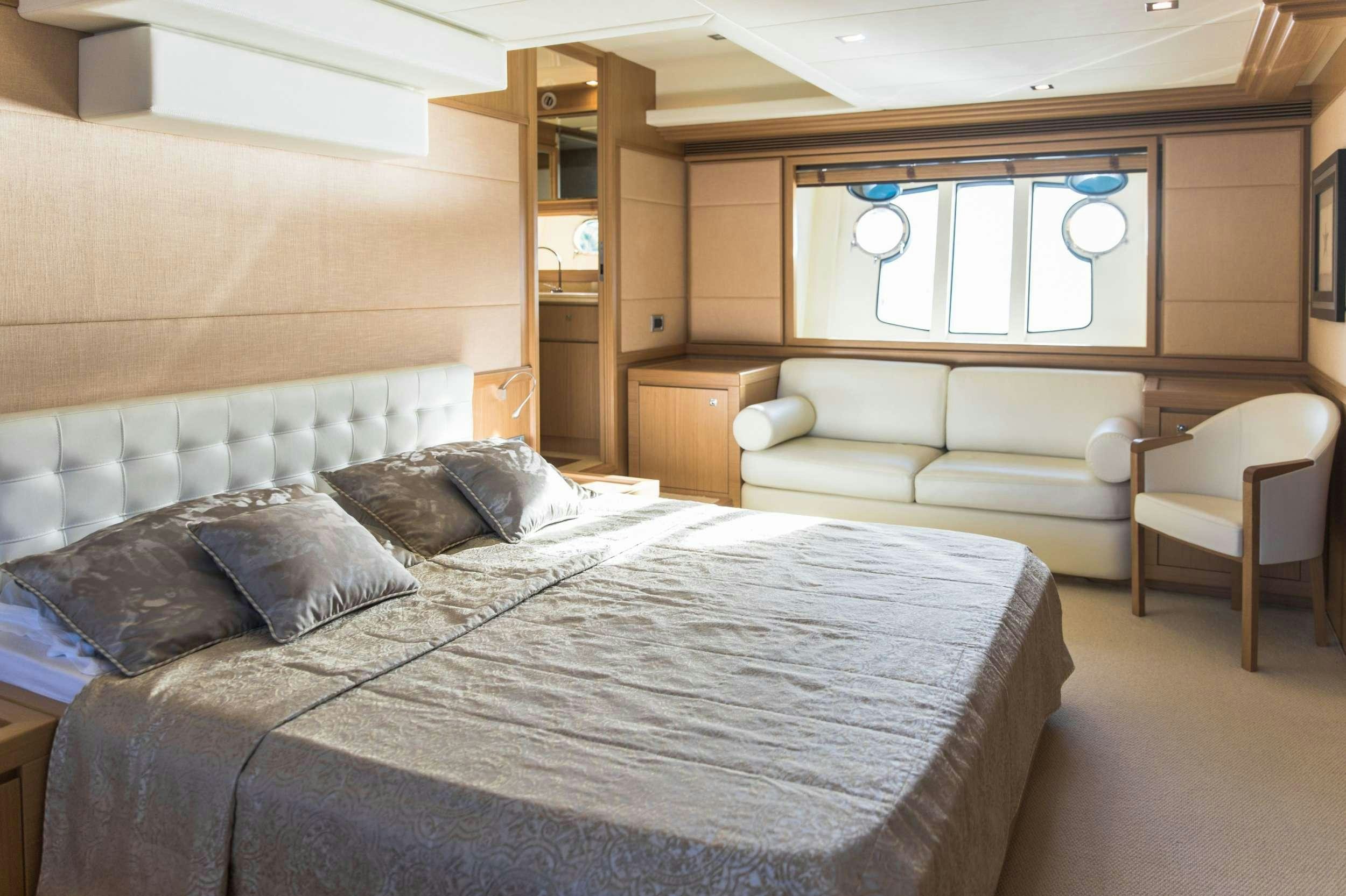 a room with a bed and a chair aboard FRIEND'S BOAT Yacht for Charter