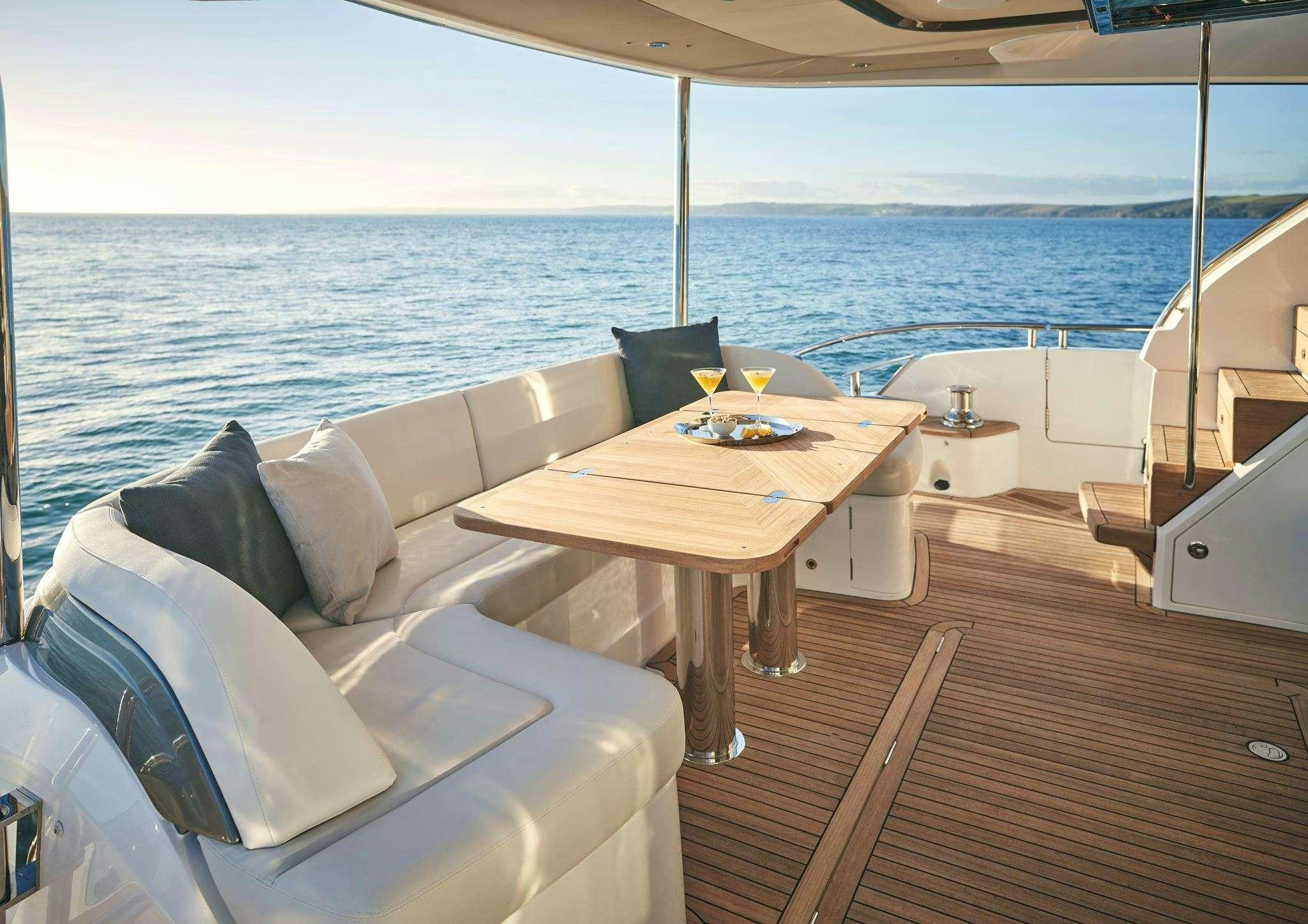 a table and chairs on a deck overlooking the ocean aboard ELIZABETH Yacht for Charter