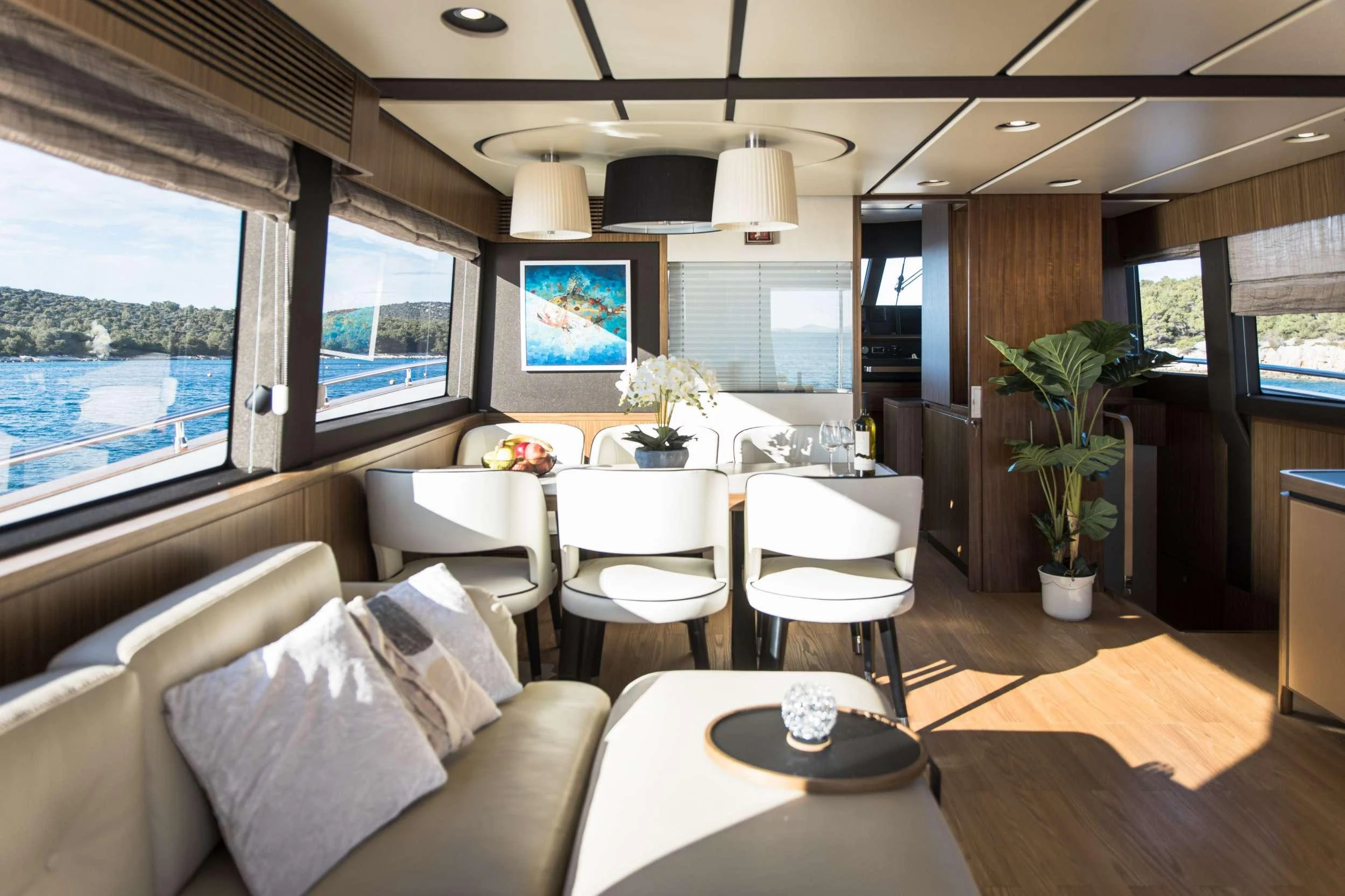 a room with a table chairs and a window aboard BOLLINGER Yacht for Charter