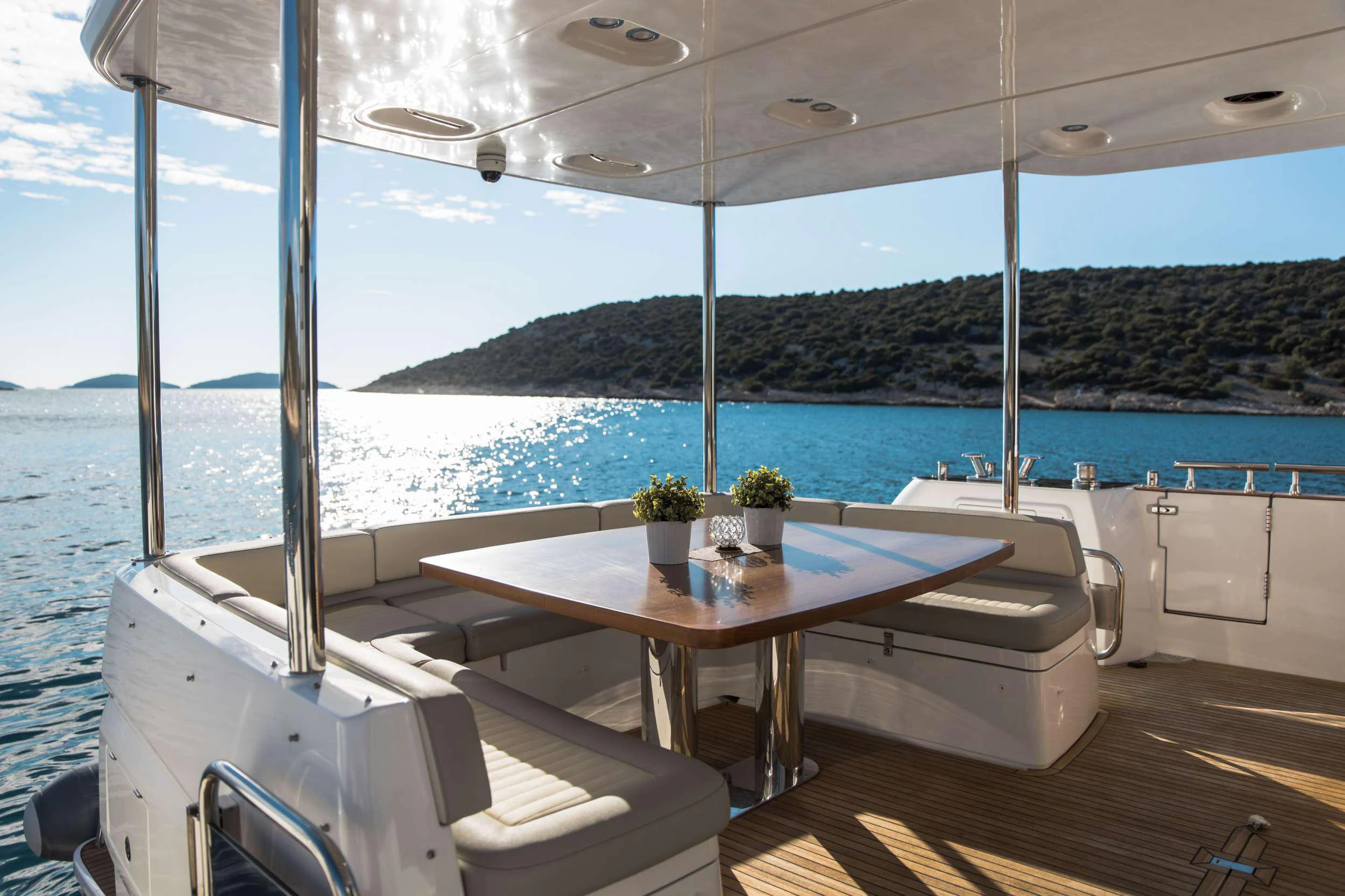 a table and chairs on a deck overlooking a body of water aboard BOLLINGER Yacht for Charter