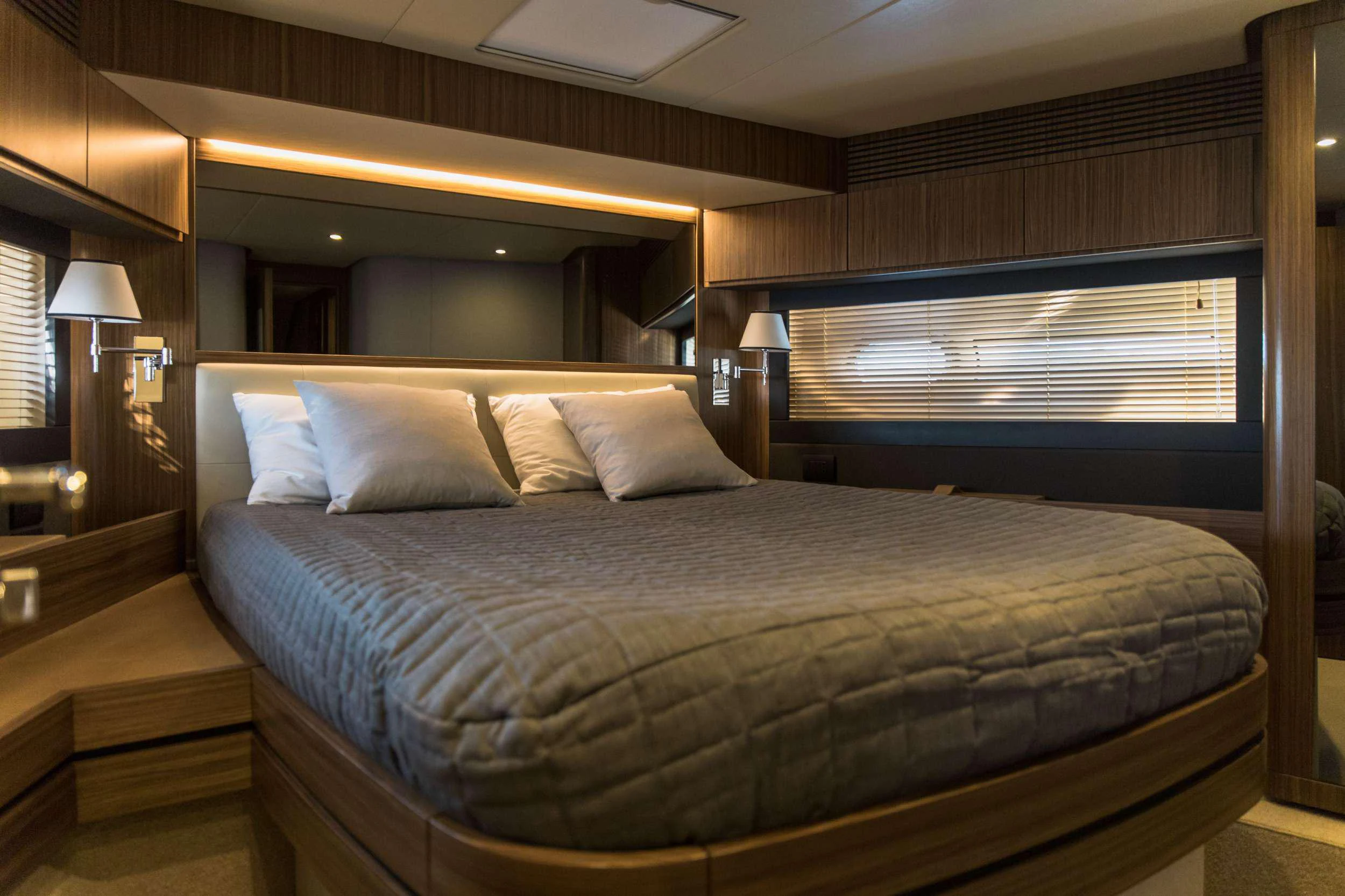 a bed with a blue comforter aboard BOLLINGER Yacht for Charter