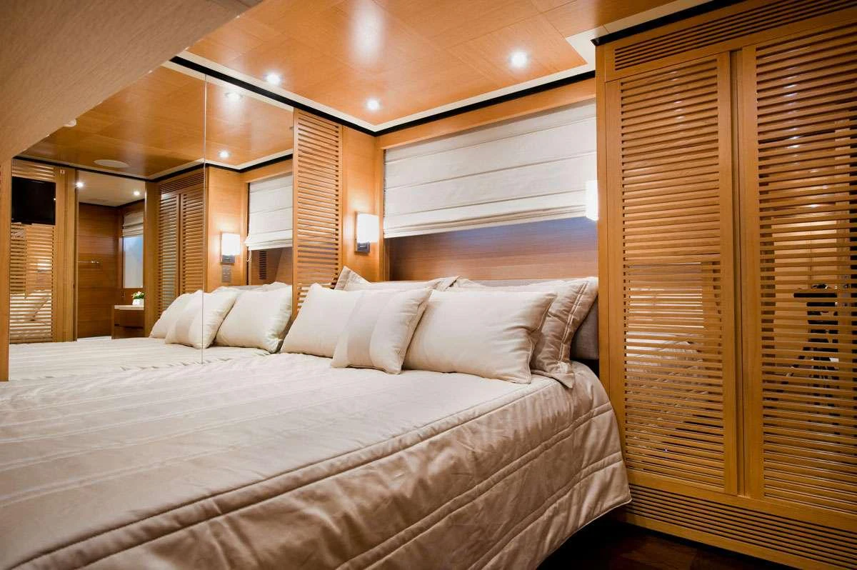 a bed with white sheets aboard LOANA Yacht for Charter