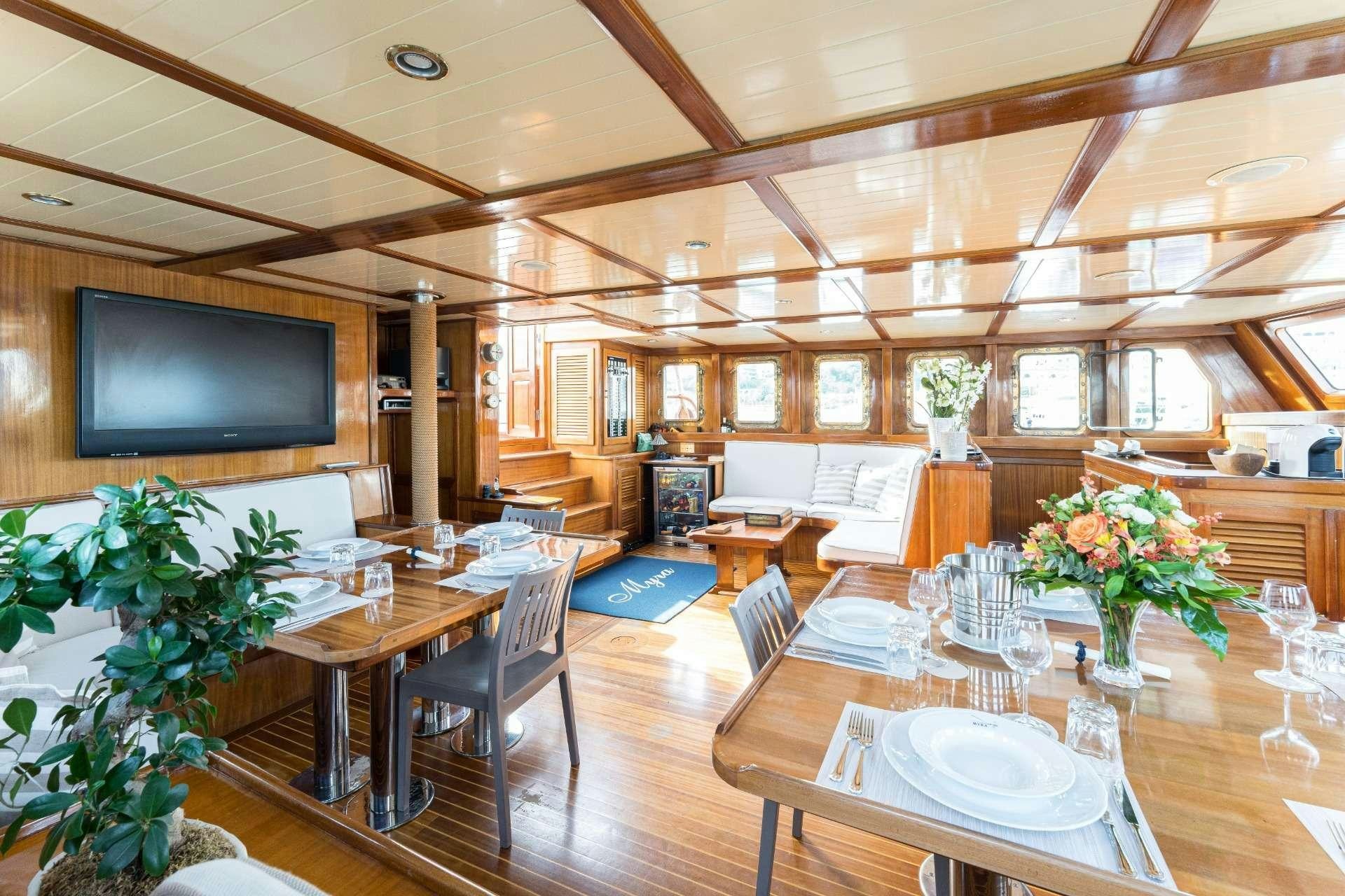 a large room with tables and chairs aboard MYRA Yacht for Charter